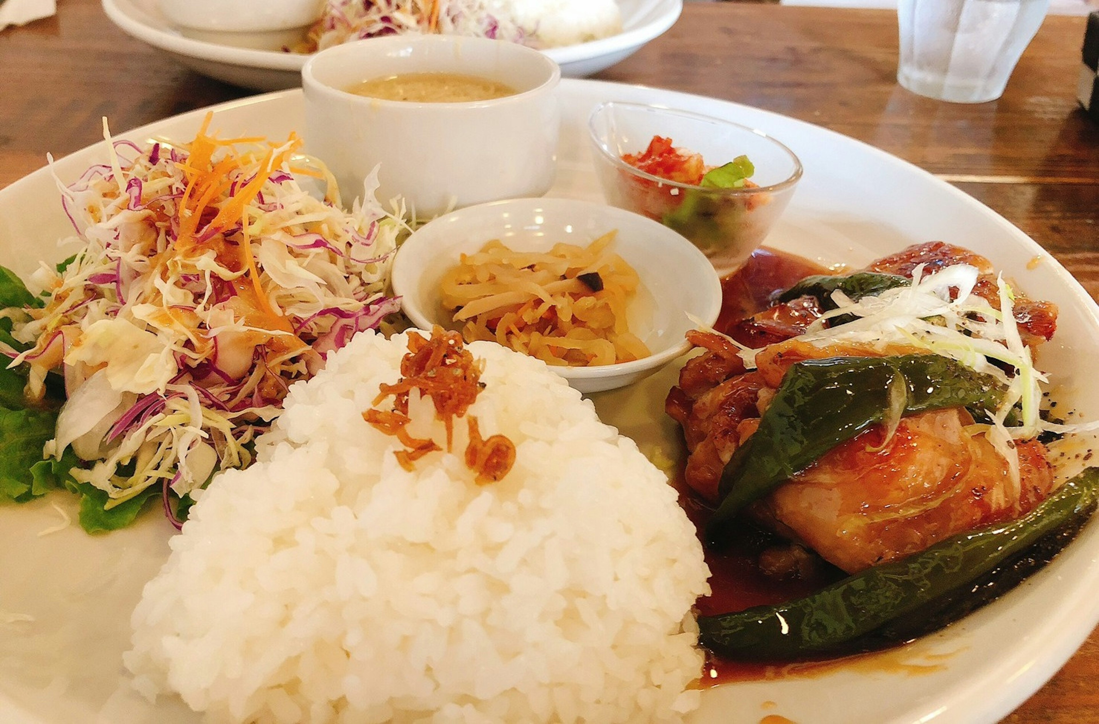 Piring nasi dengan ayam, salad, dan saus