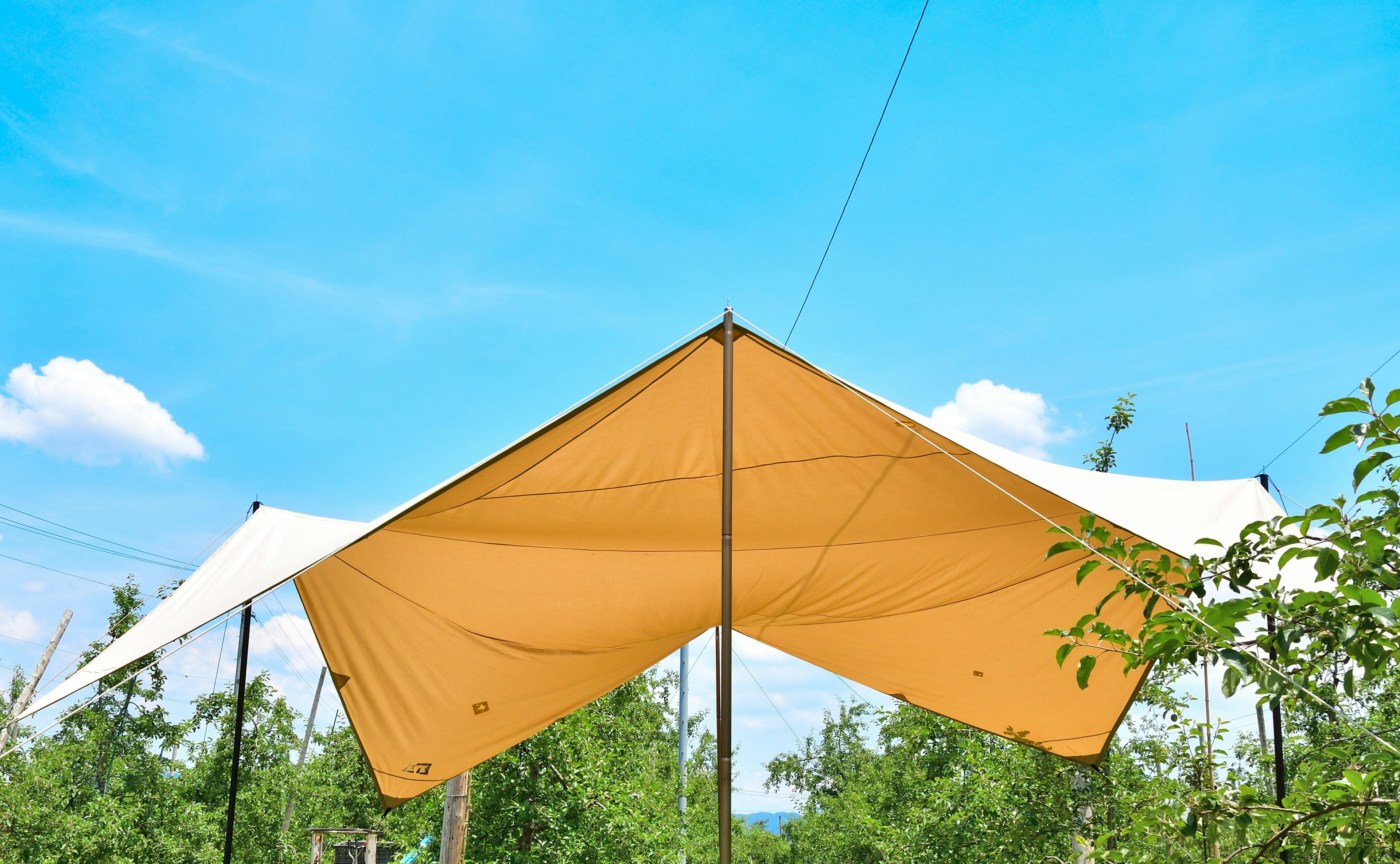 Una tenda gialla e bianca sotto un cielo blu