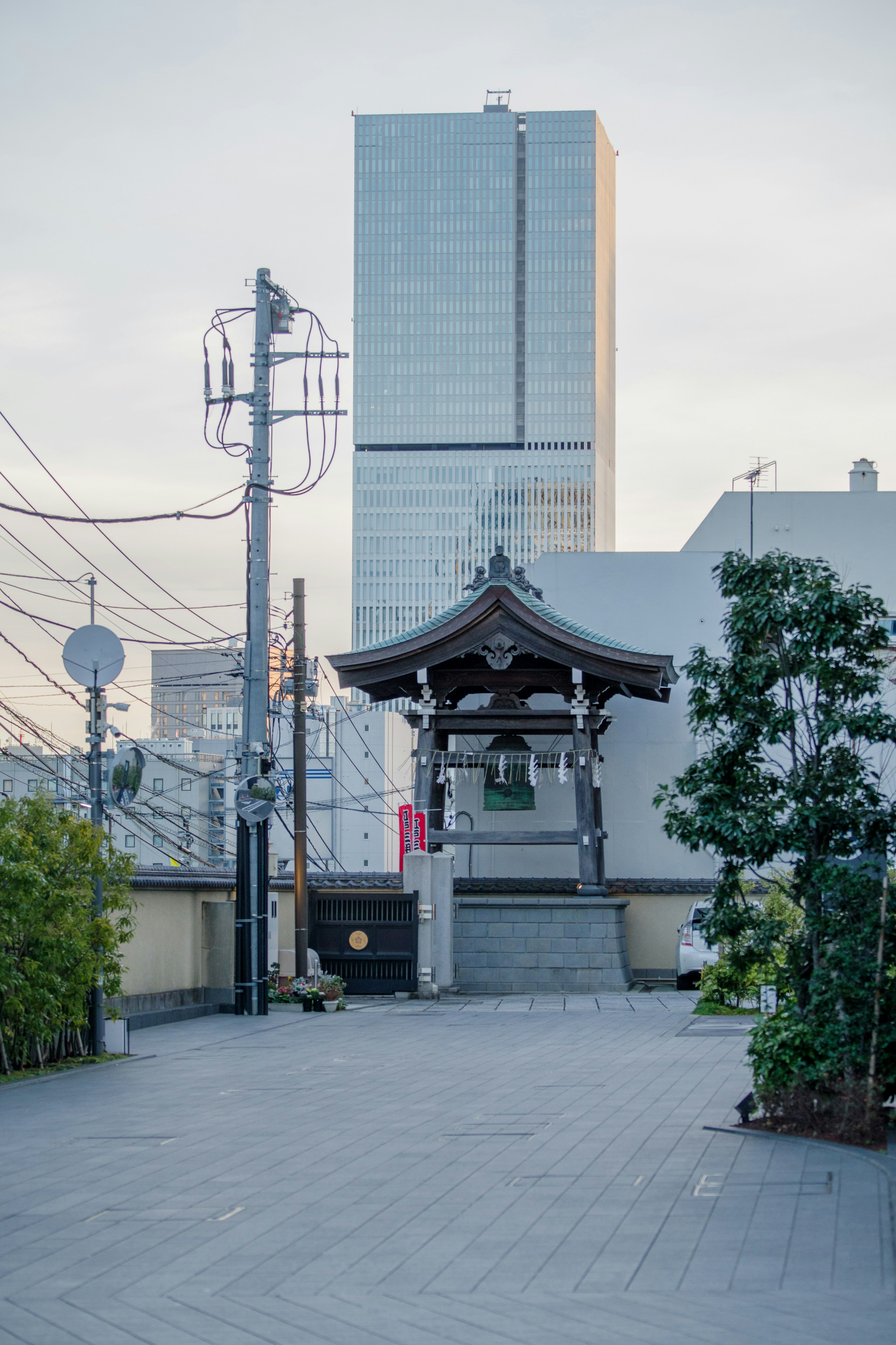 Traditional shrine gate with a modern building in the background