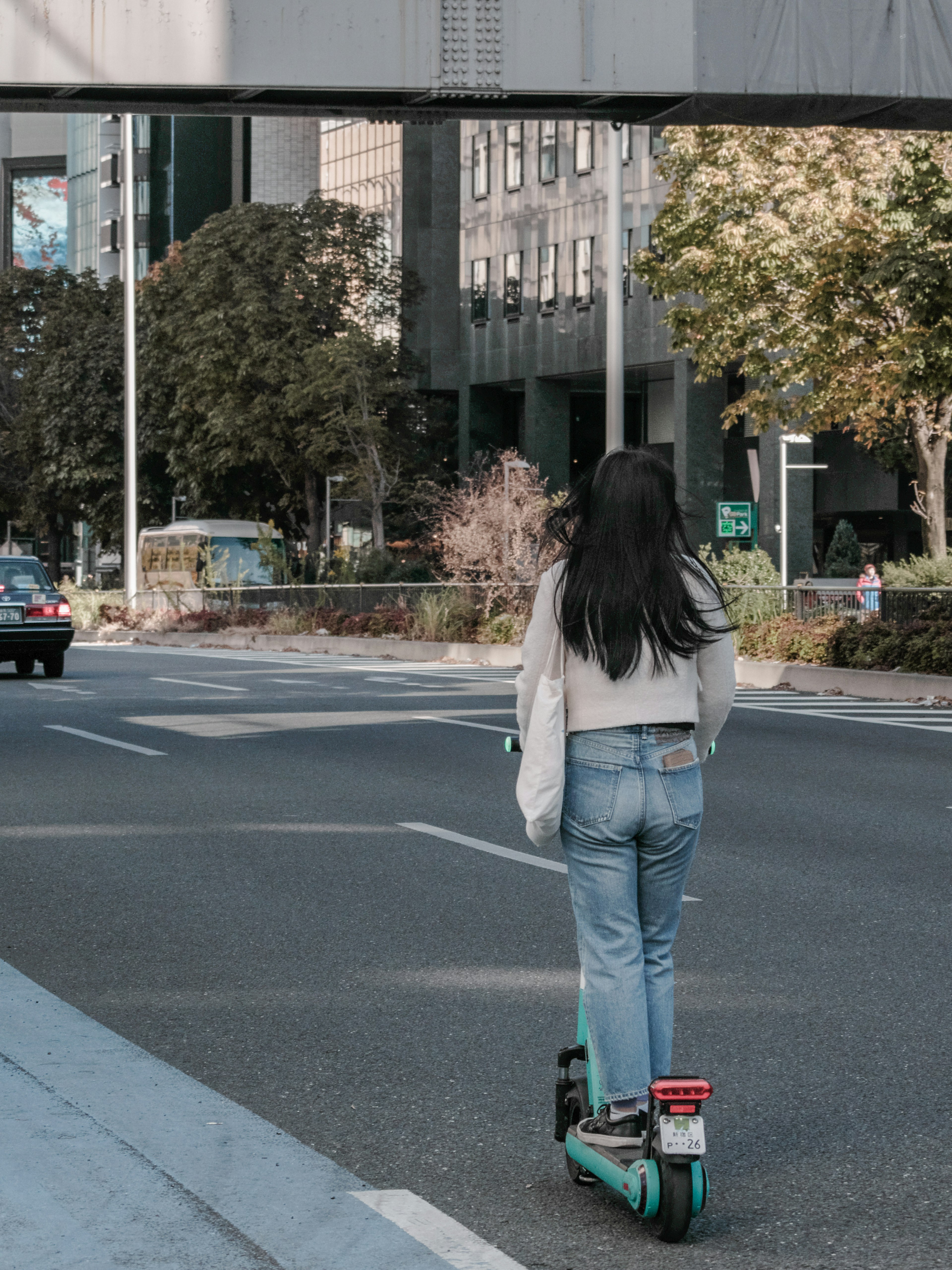 一名女性在城市街道上骑电动滑板车