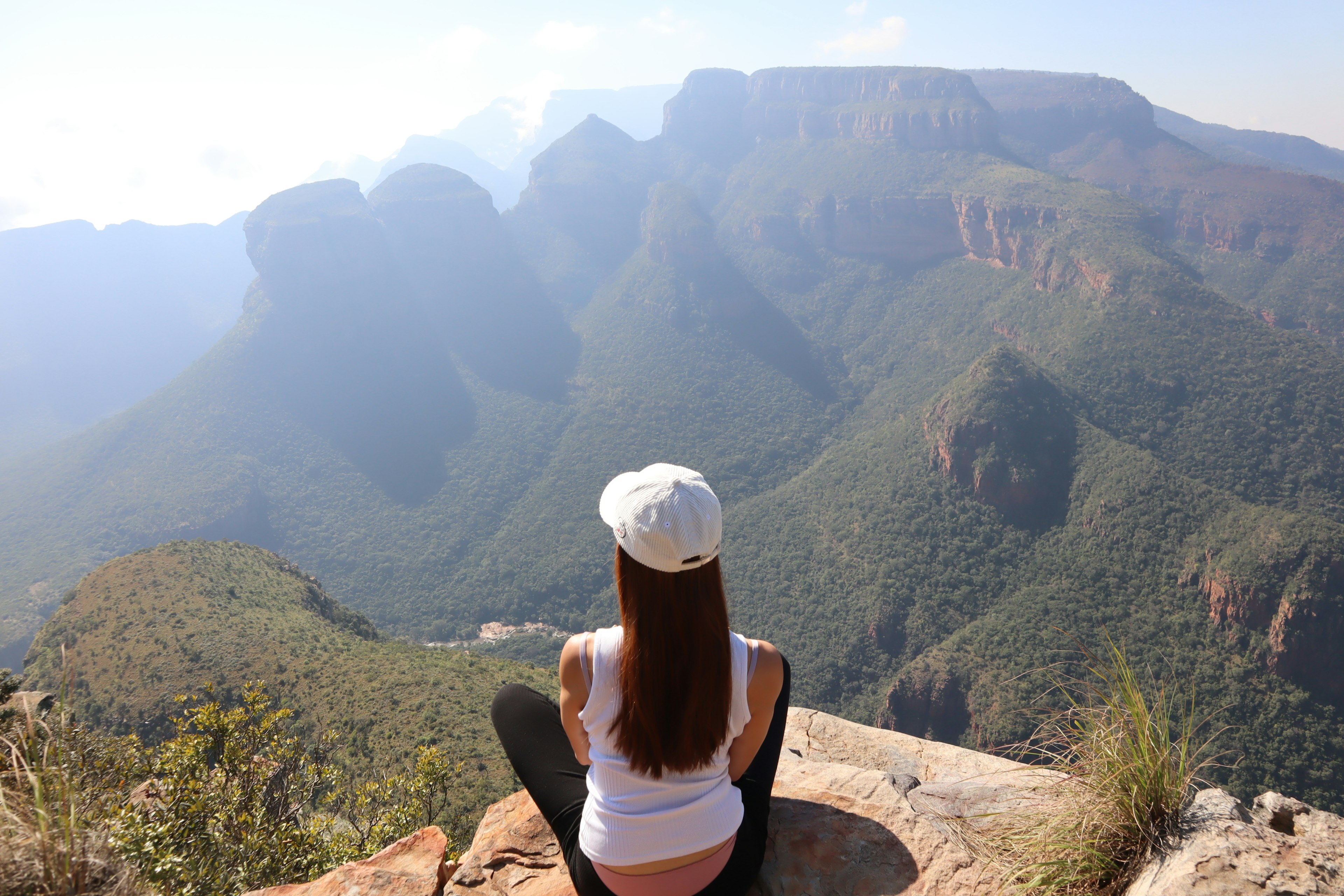 Mujer contemplando un impresionante paisaje montañoso con colinas verdes