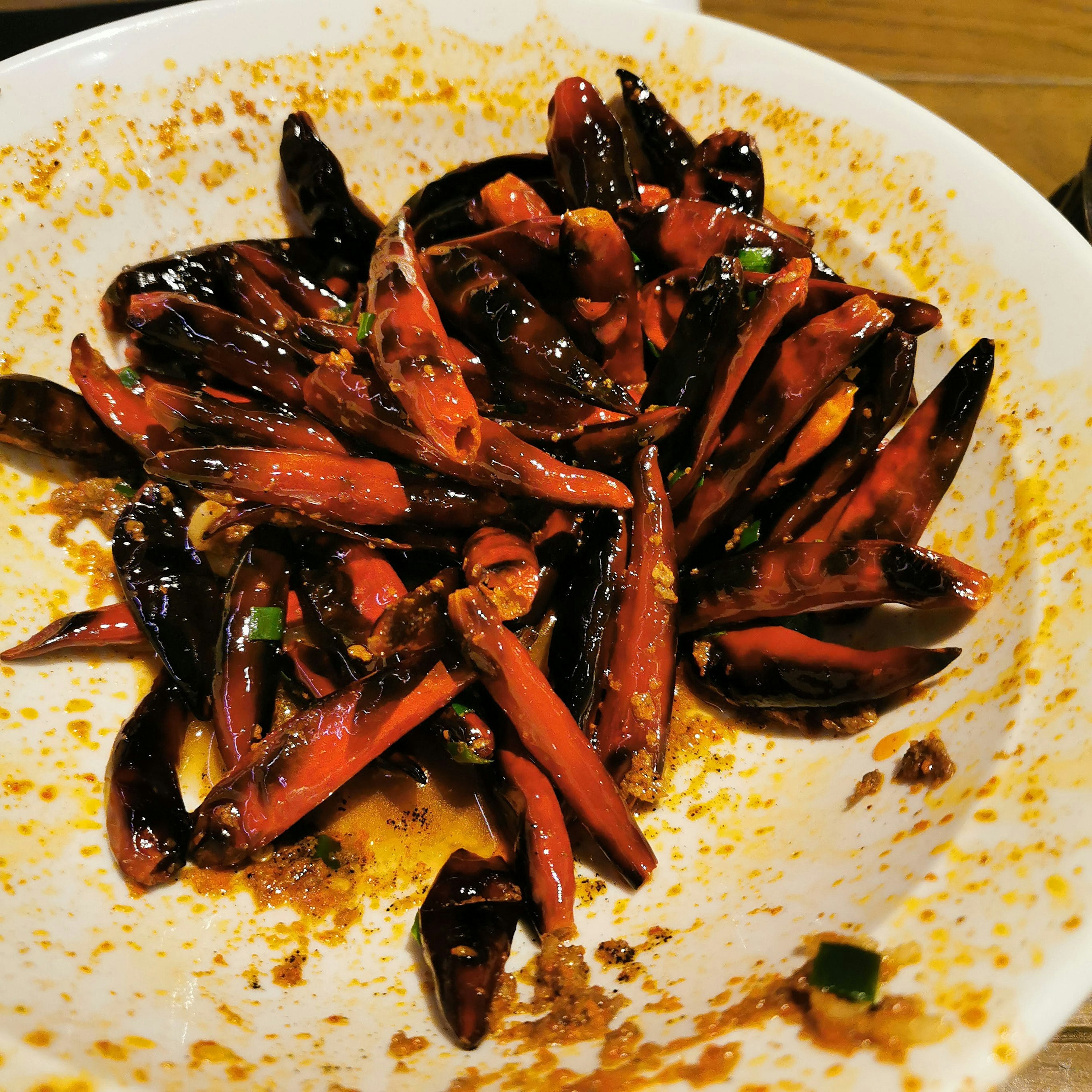 Une assiette remplie de piments rouges et noirs