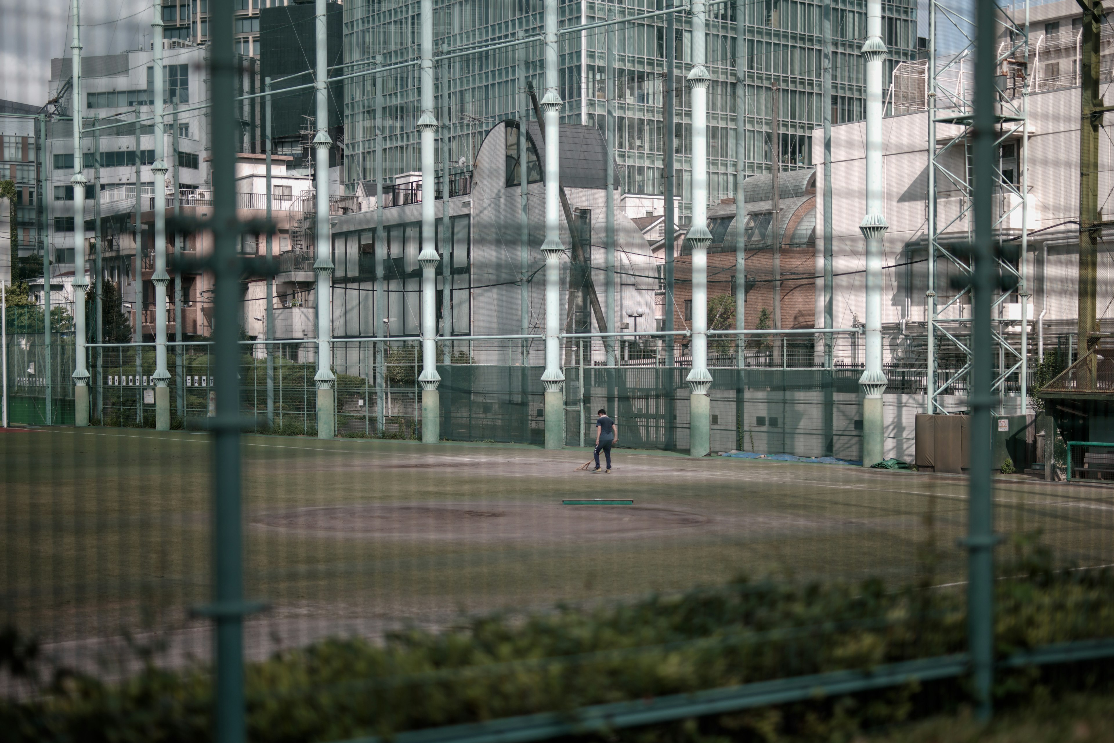 Campo abierto rodeado de edificios modernos y cercas