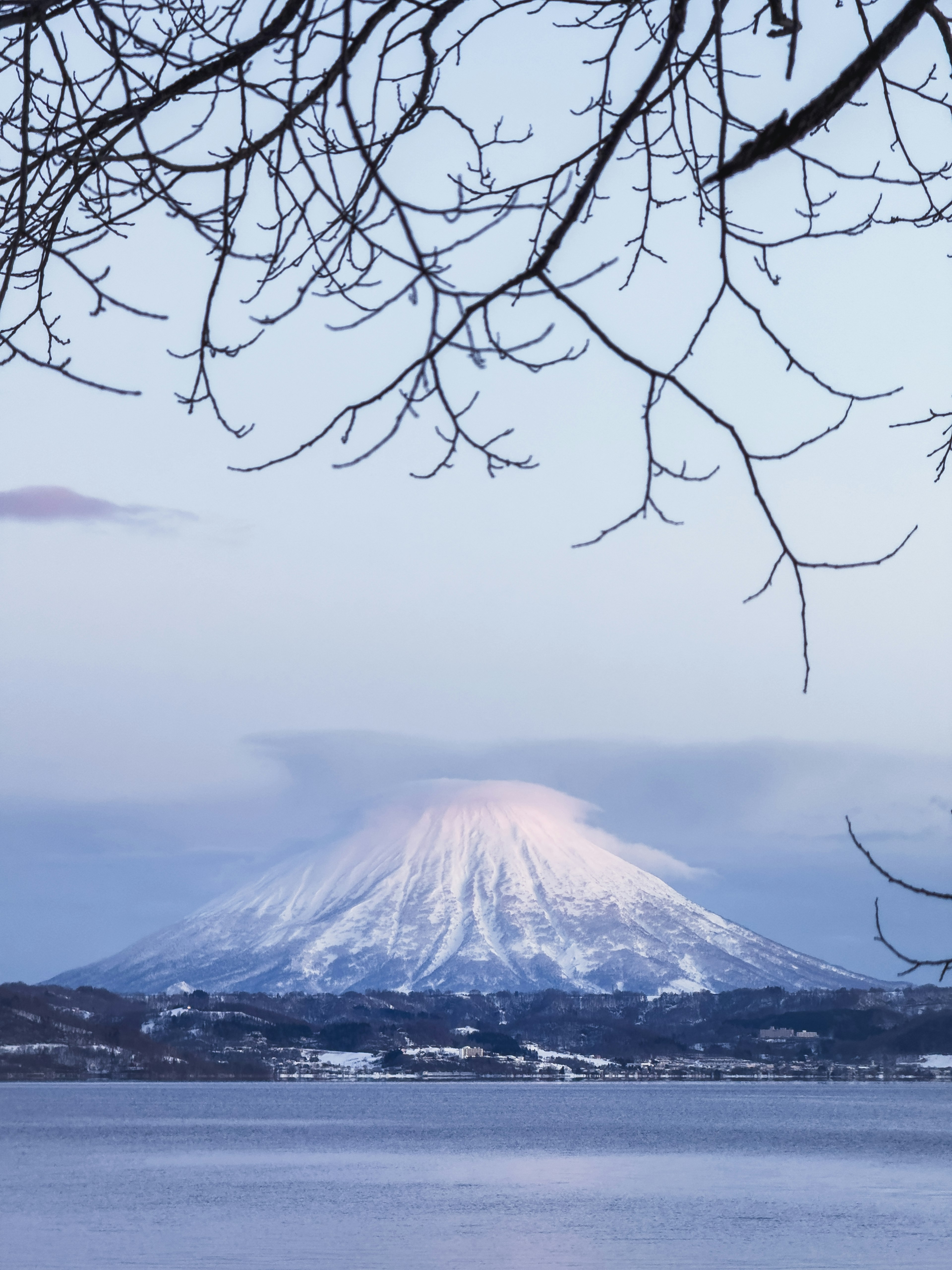 Montagna innevata con vista su un lago tranquillo