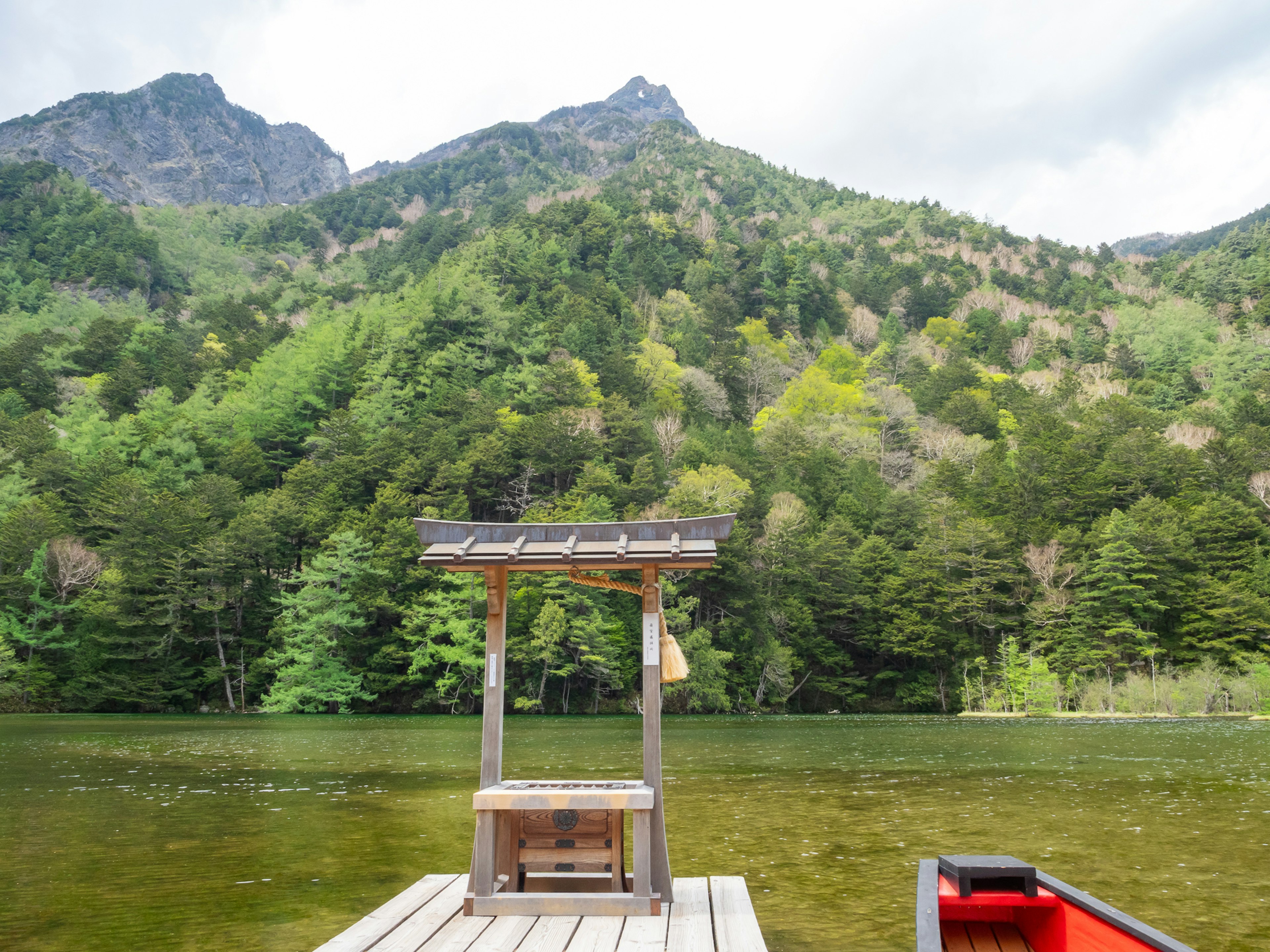 Vista escénica de un lago tranquilo con montañas circundantes y un pequeño muelle