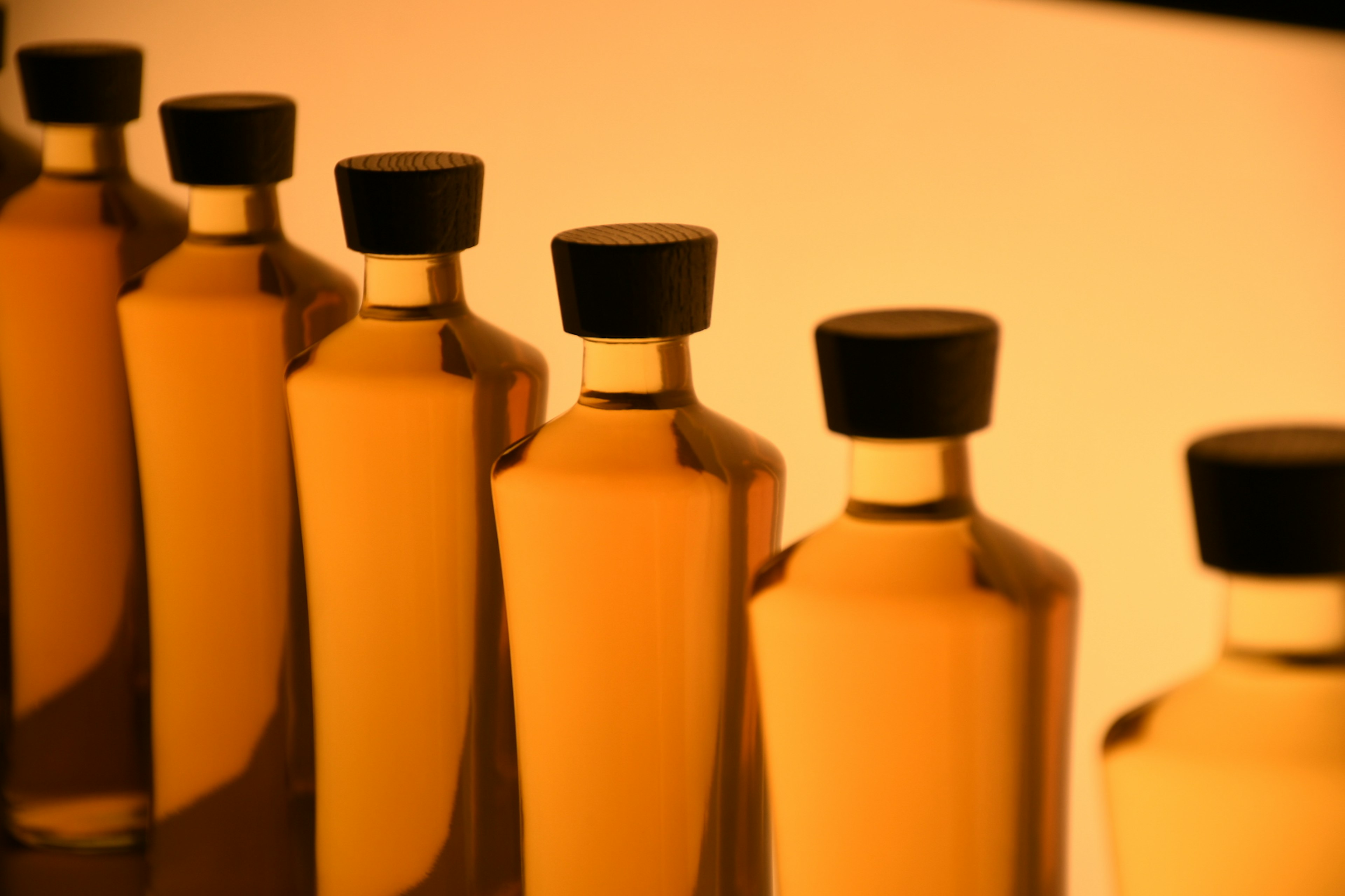 Row of bottles filled with golden liquid