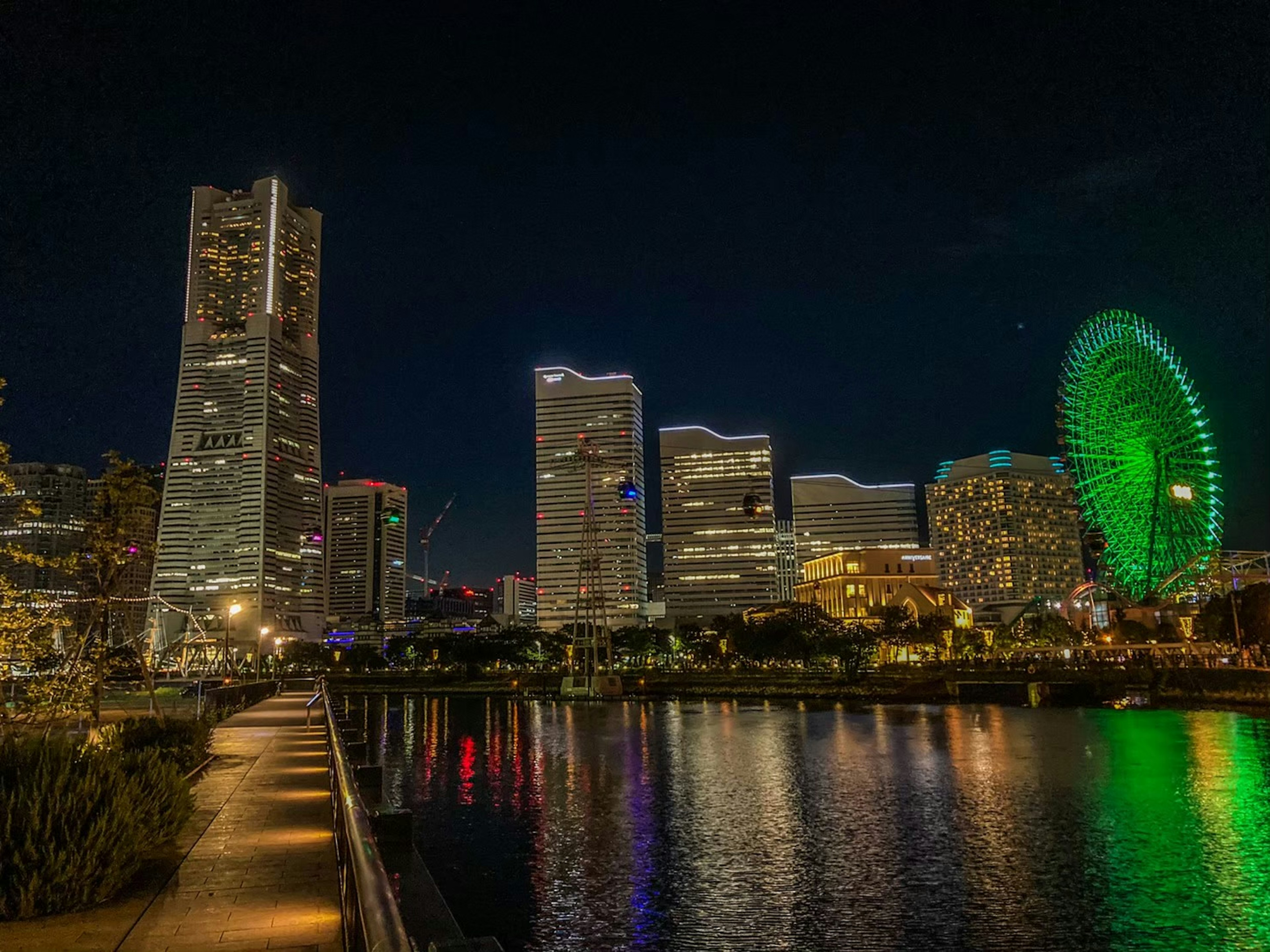 Vista notturna dello skyline di Yokohama con ruota panoramica verde