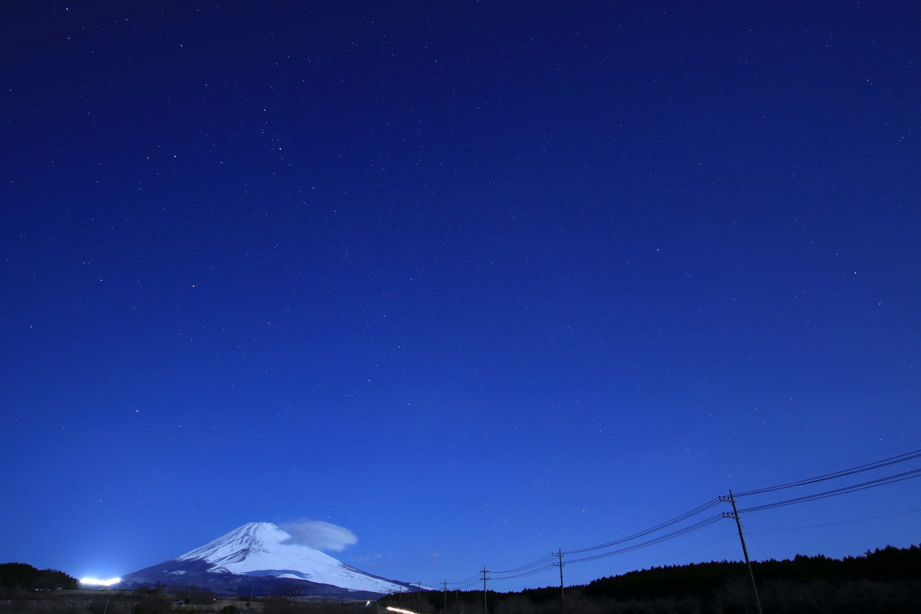 Silhouette des Fuji gegen einen tiefblauen Nachthimmel voller Sterne