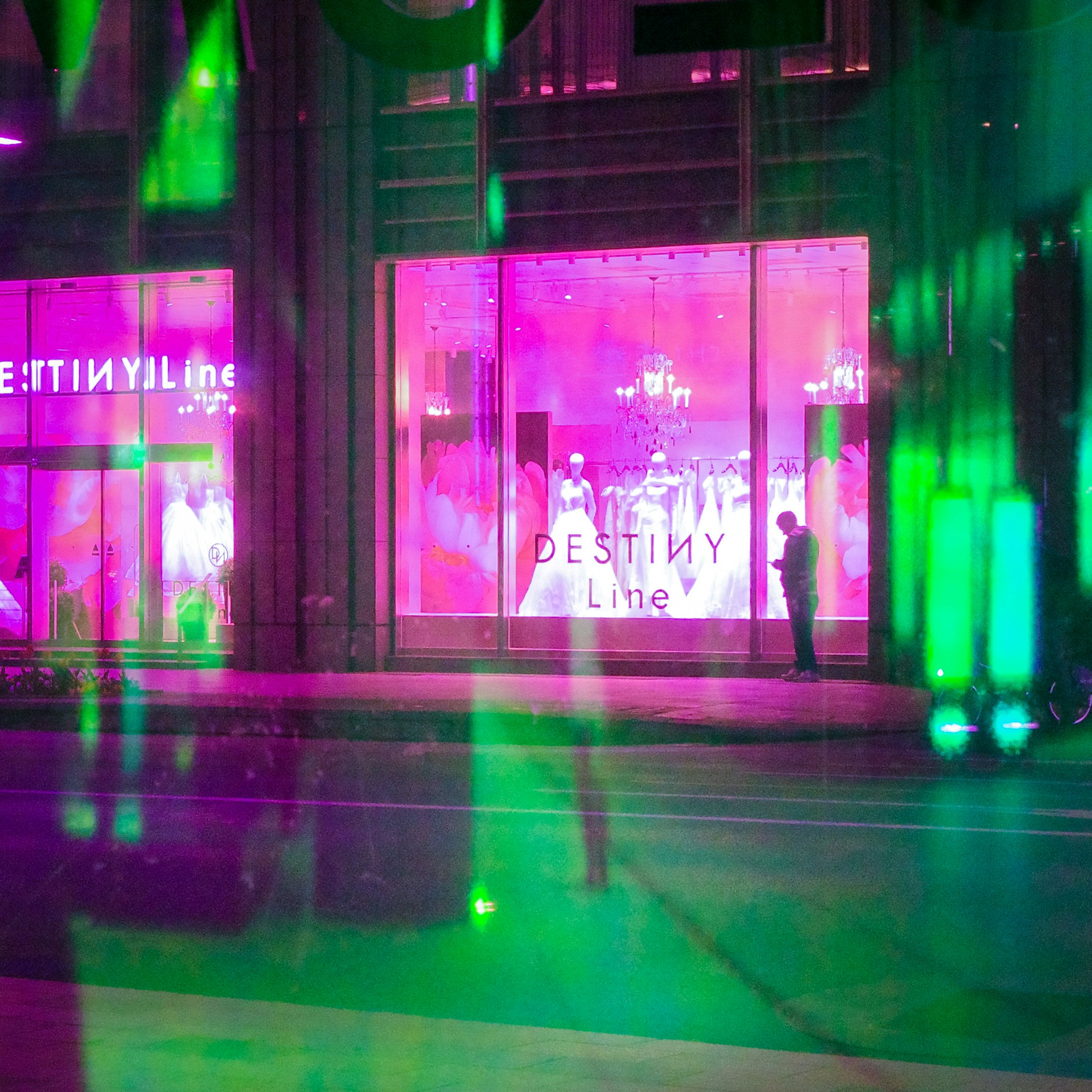 Fashion show scene reflected in colorful window lights