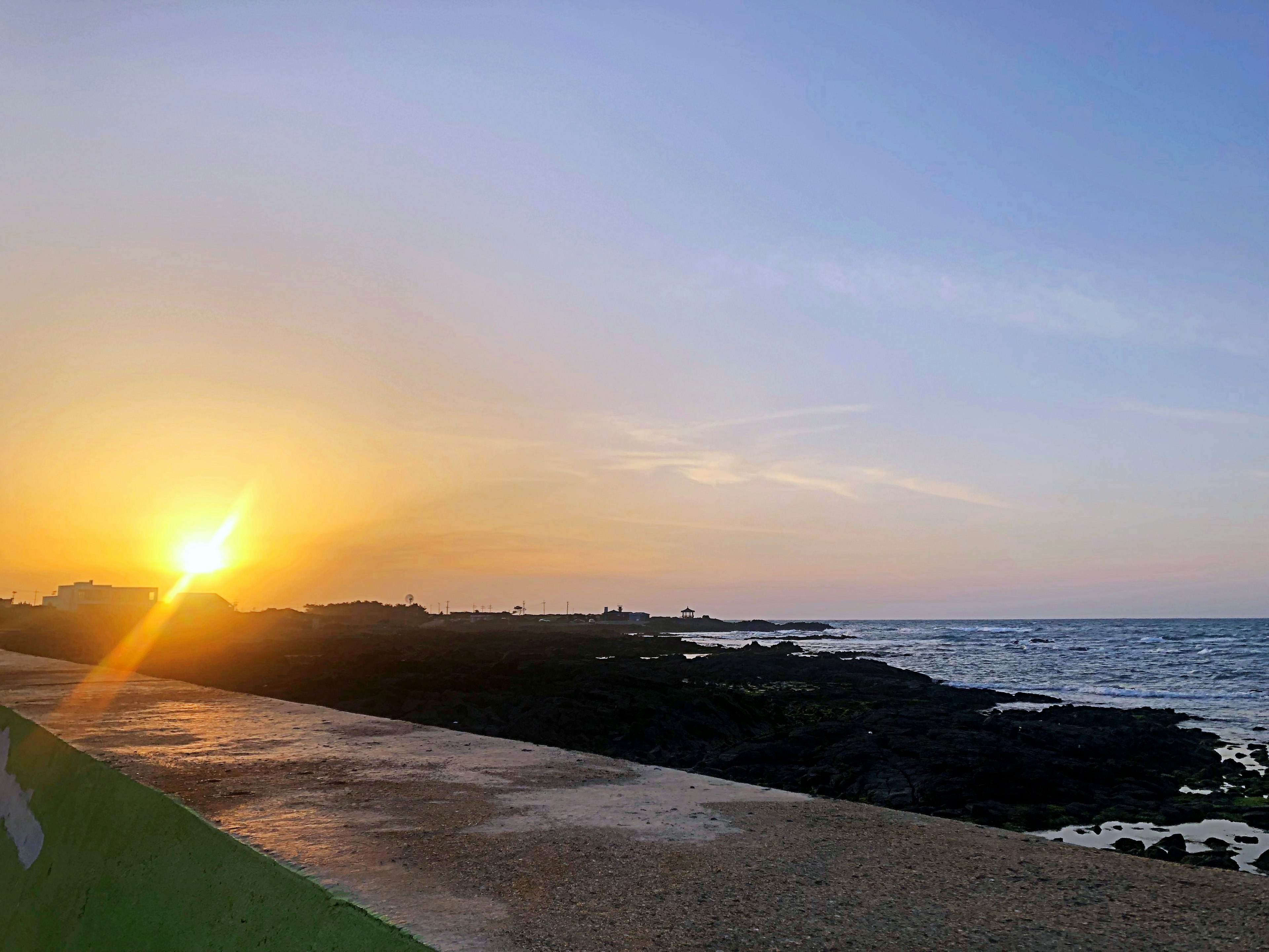 Bellissimo tramonto sull'oceano con una costa rocciosa e onde leggere