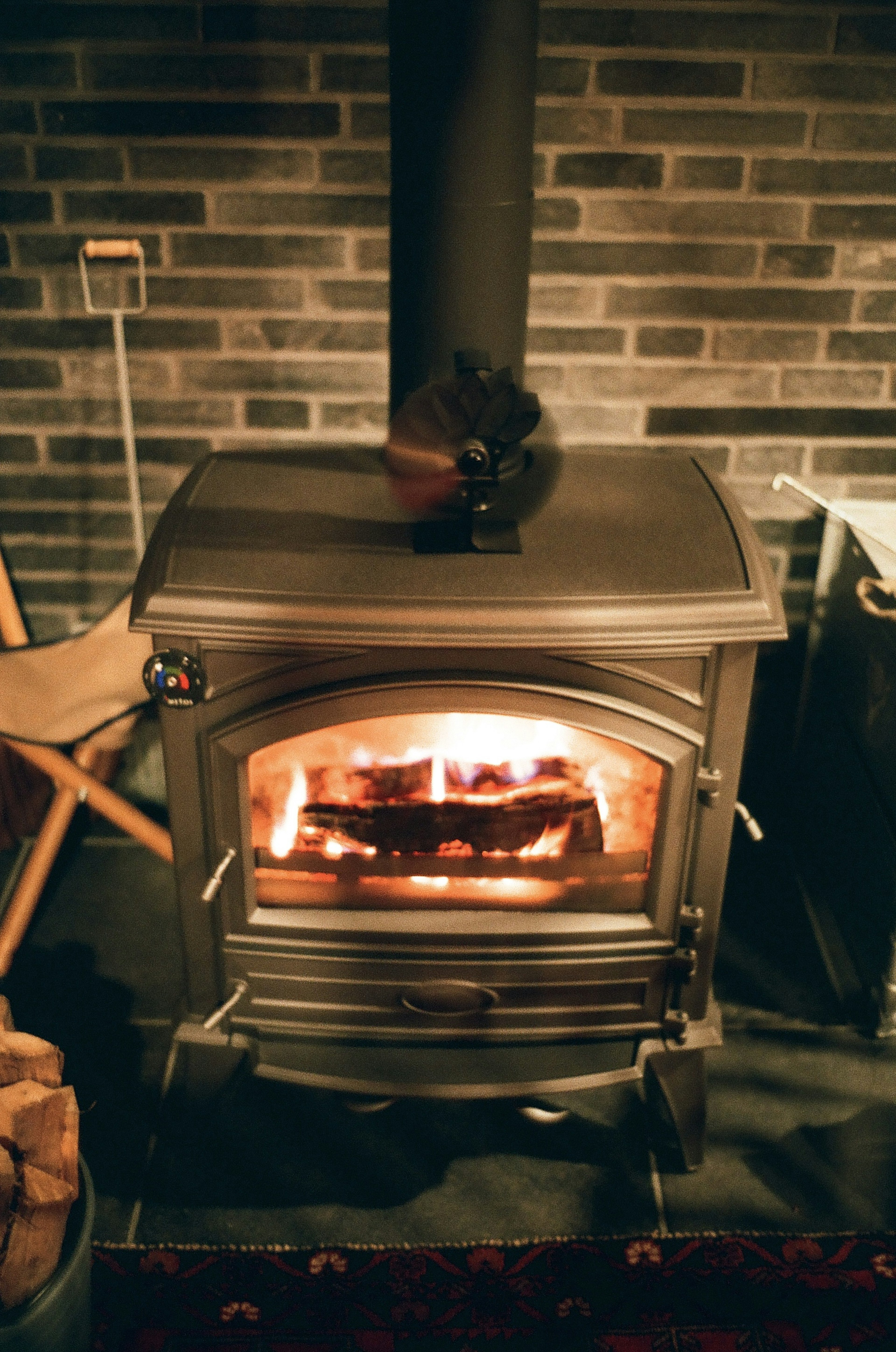 Cozy space with a burning stove and a brick wall