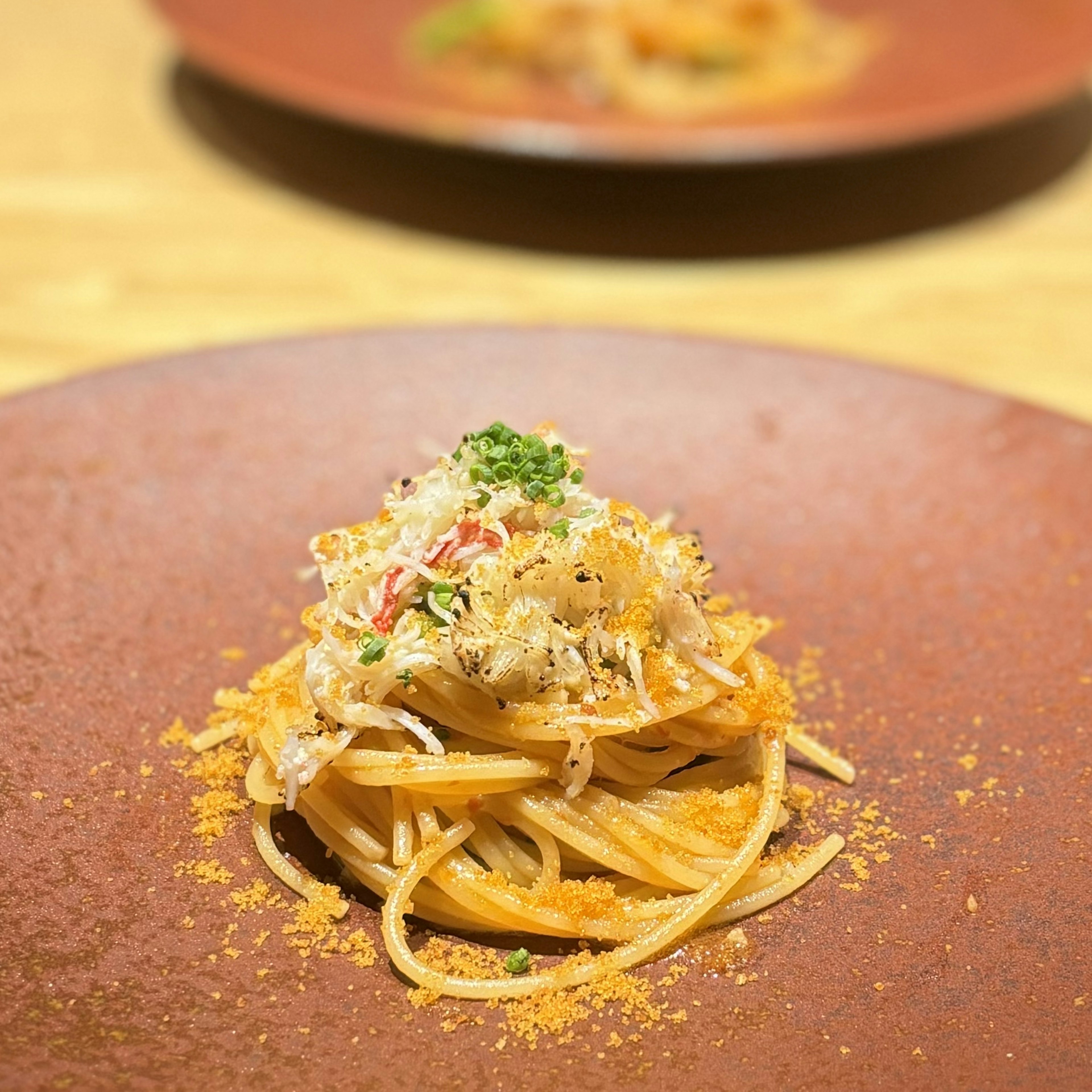 スパゲッティに蟹肉と香草がトッピングされた料理