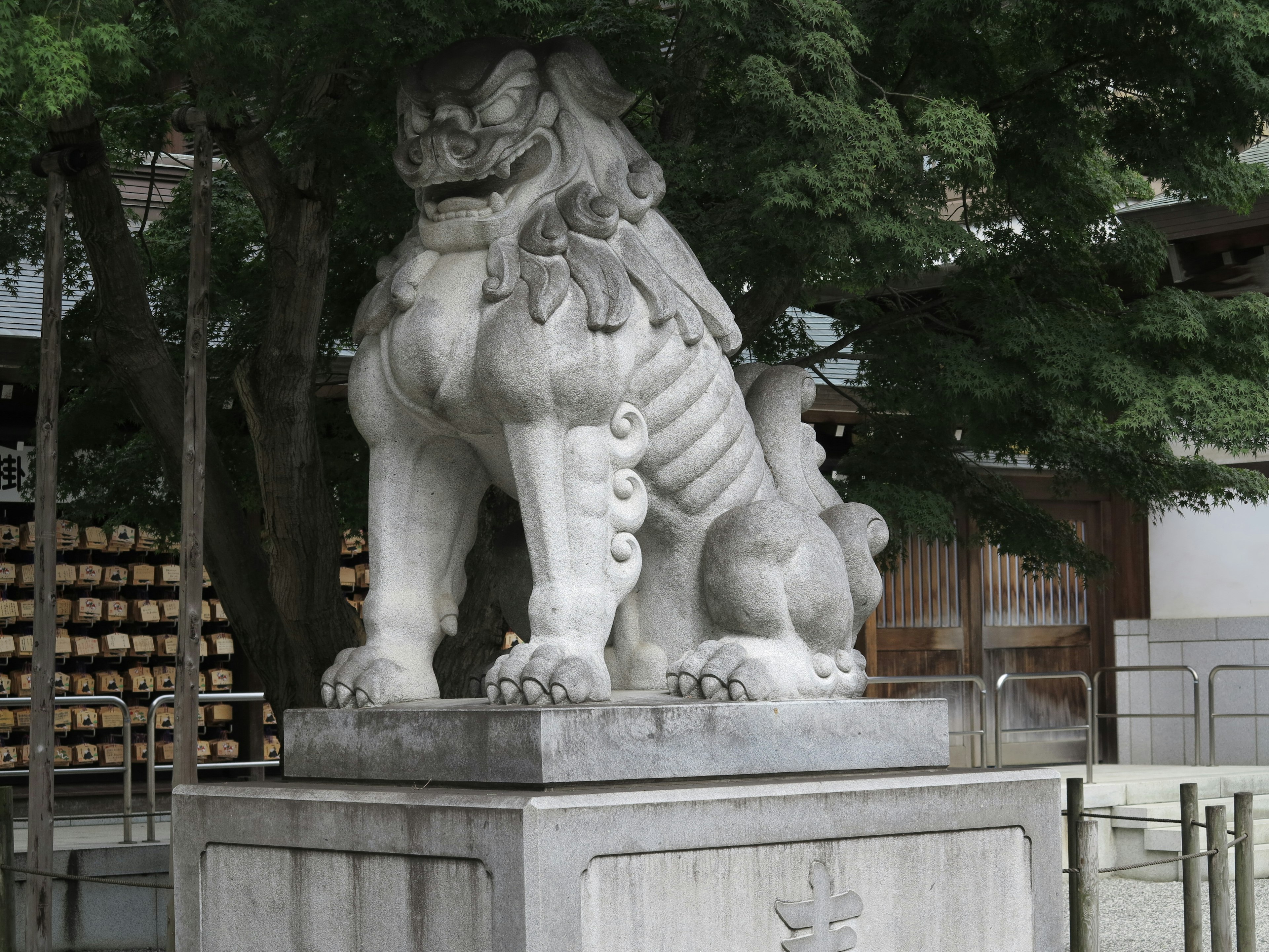 Statua di leone bianco che si erge nel cortile di un santuario