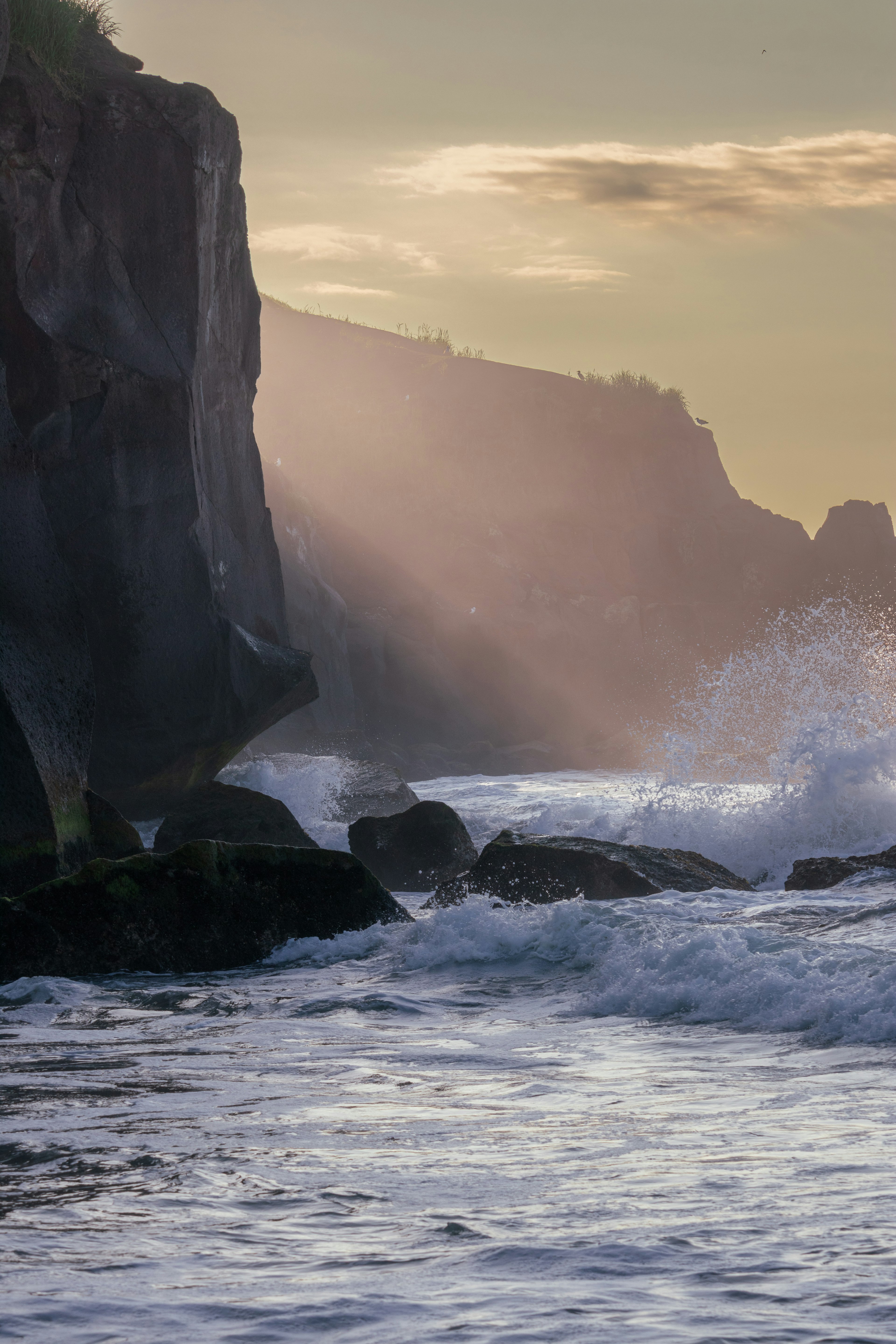 Beautiful coastal scene with rocks and waves illuminated by soft light