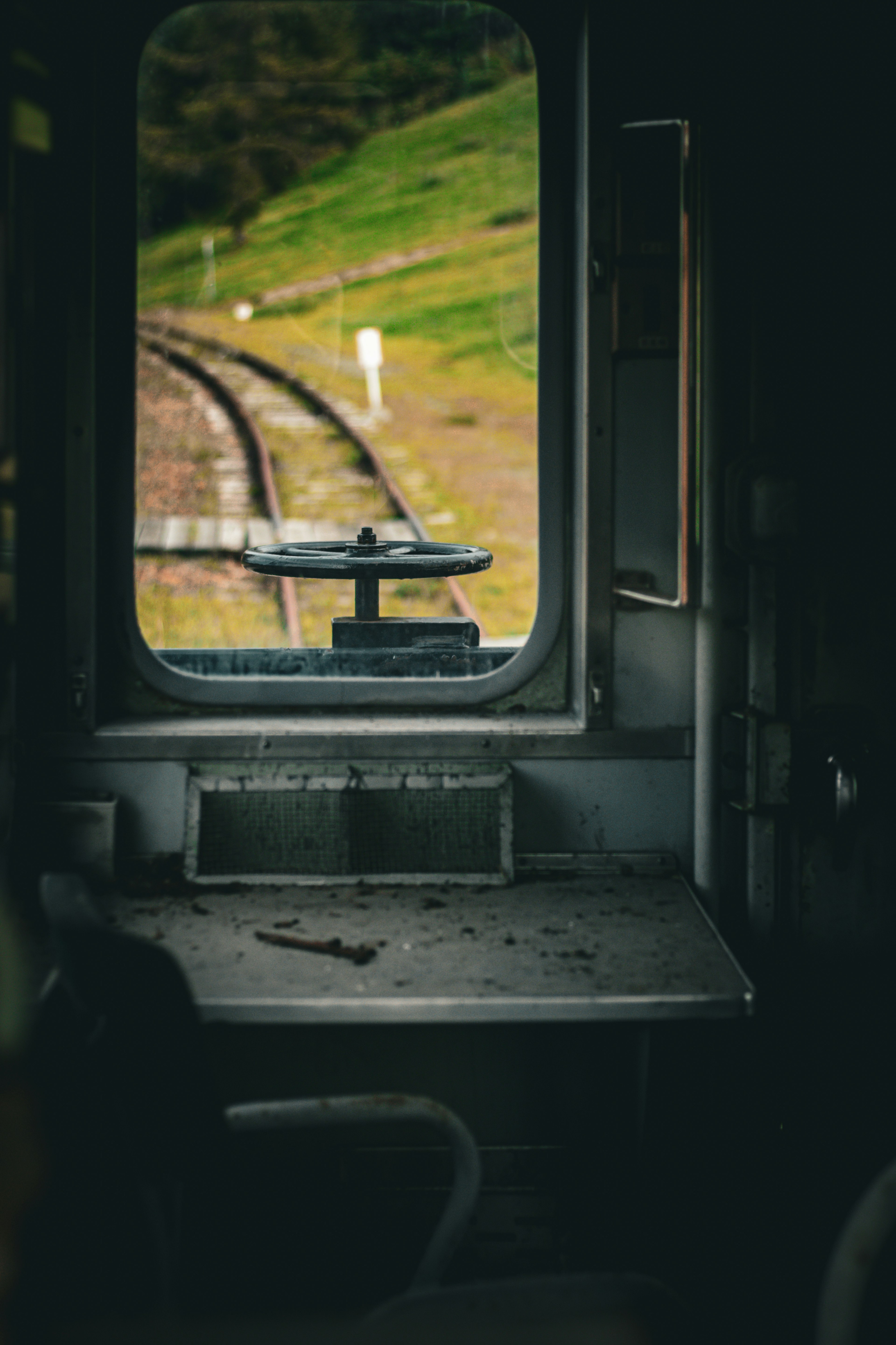 Vista dalla cabina di un treno che mostra i binari e un paesaggio verde attraverso la finestra