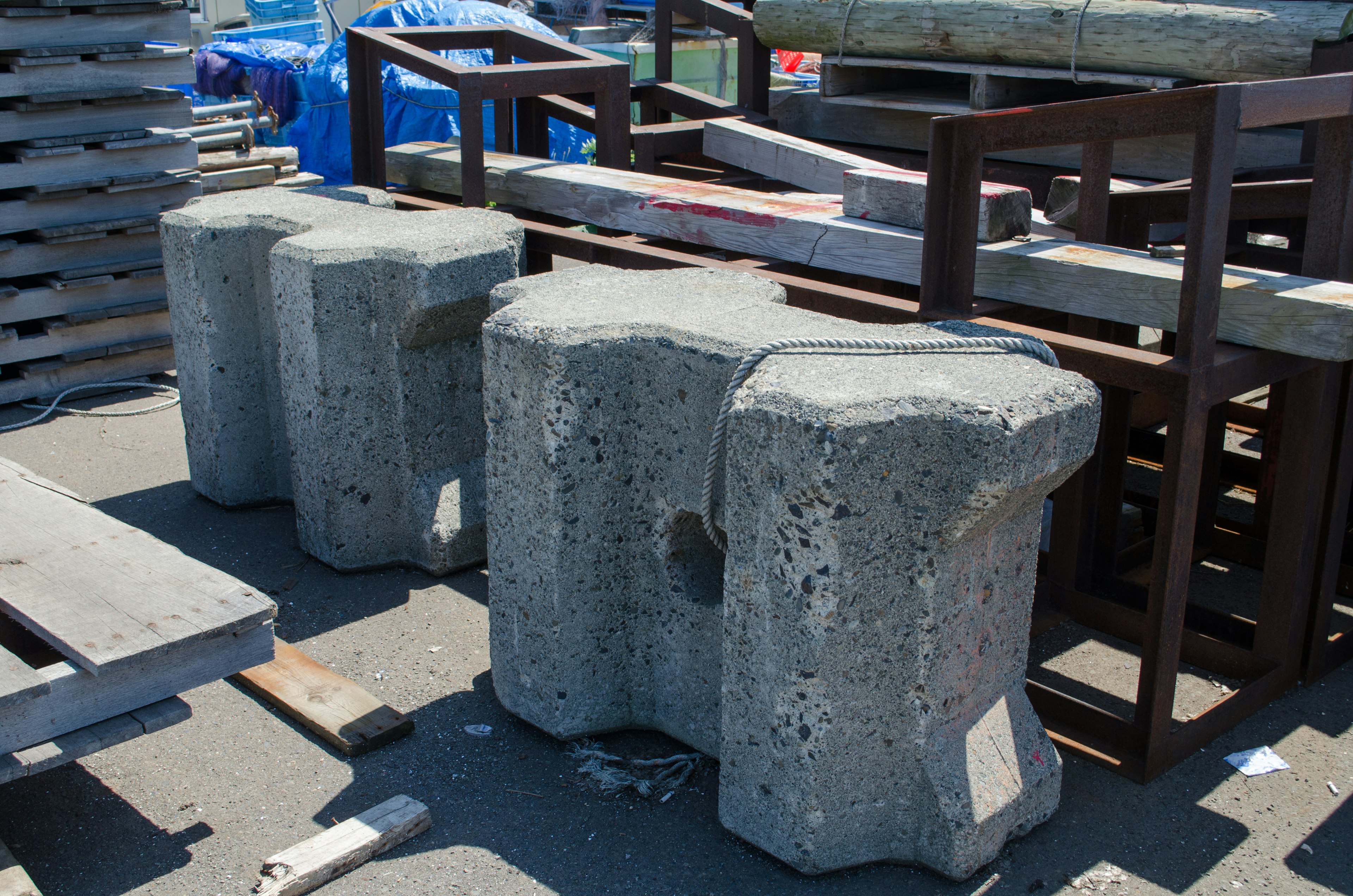 Image featuring concrete blocks arranged with wooden pallets and metal structures in the background