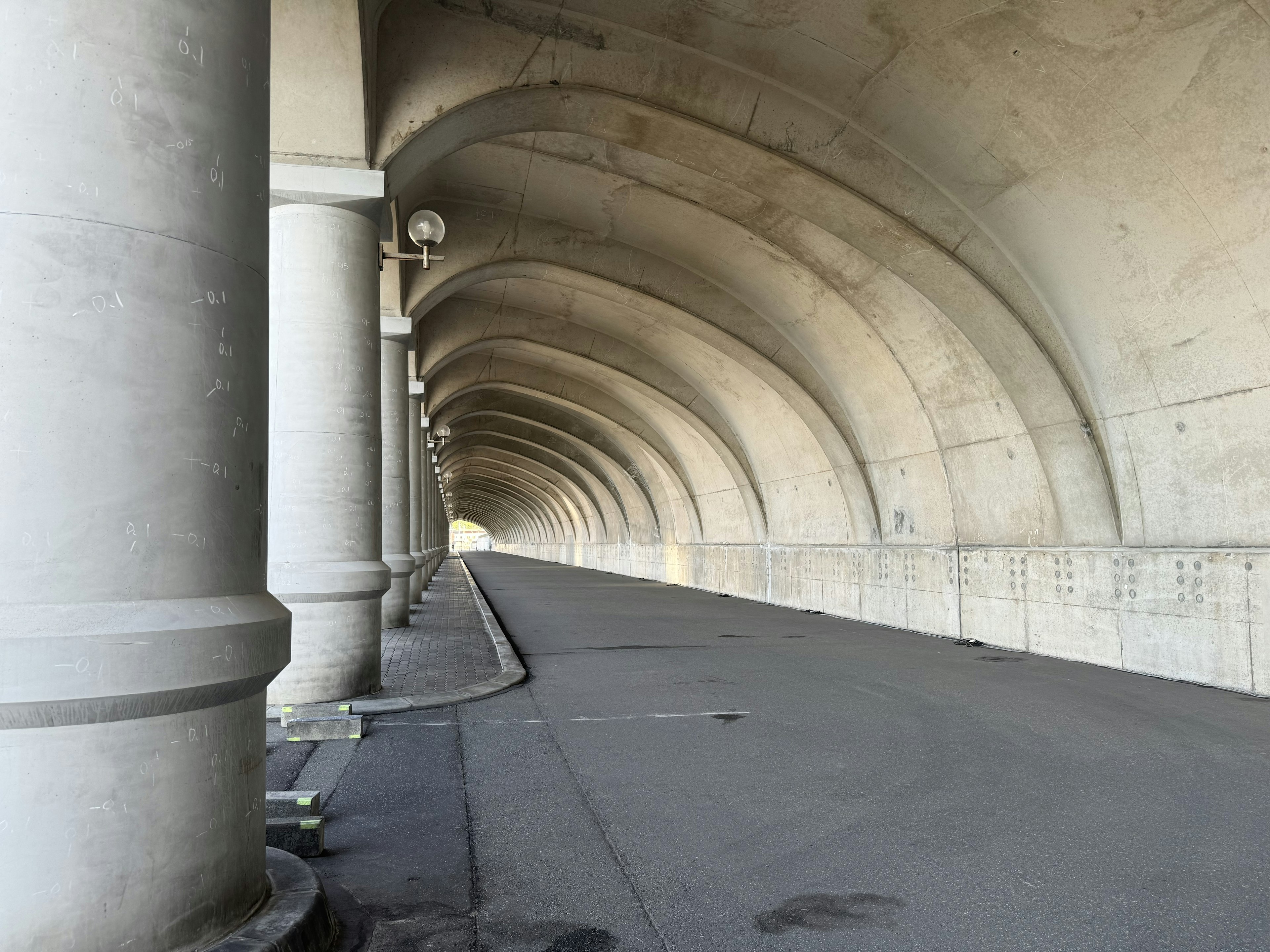 Grand tunnel en béton avec des arches et des colonnes sur le côté