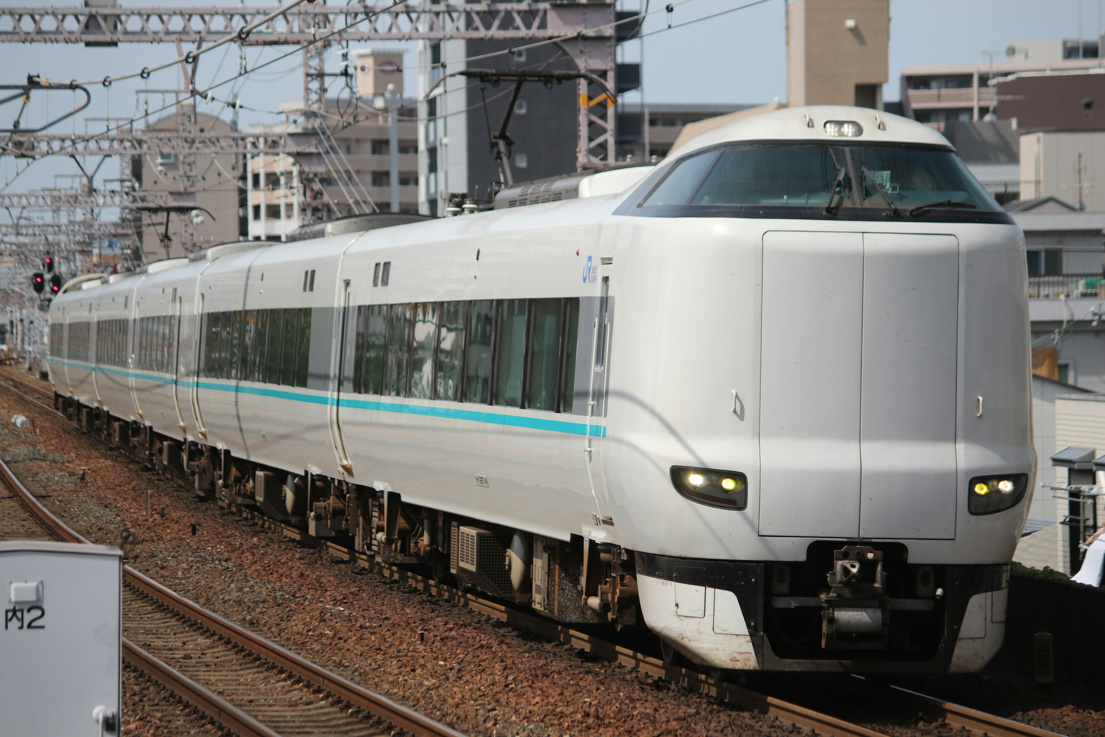 Un tren Shinkansen blanco viajando a través de un entorno urbano