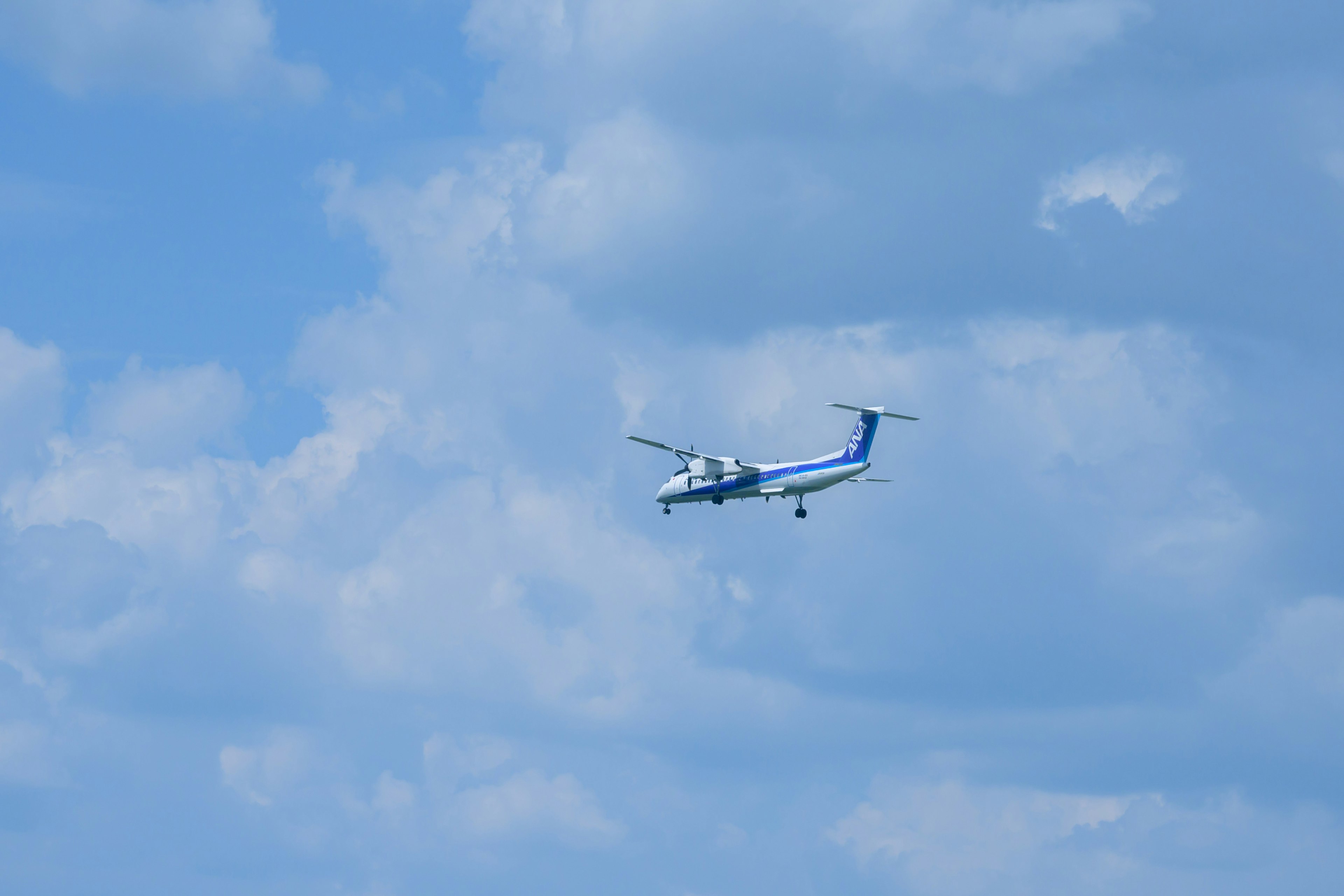 Kleines blau-weißes Flugzeug fliegt in einem klaren blauen Himmel