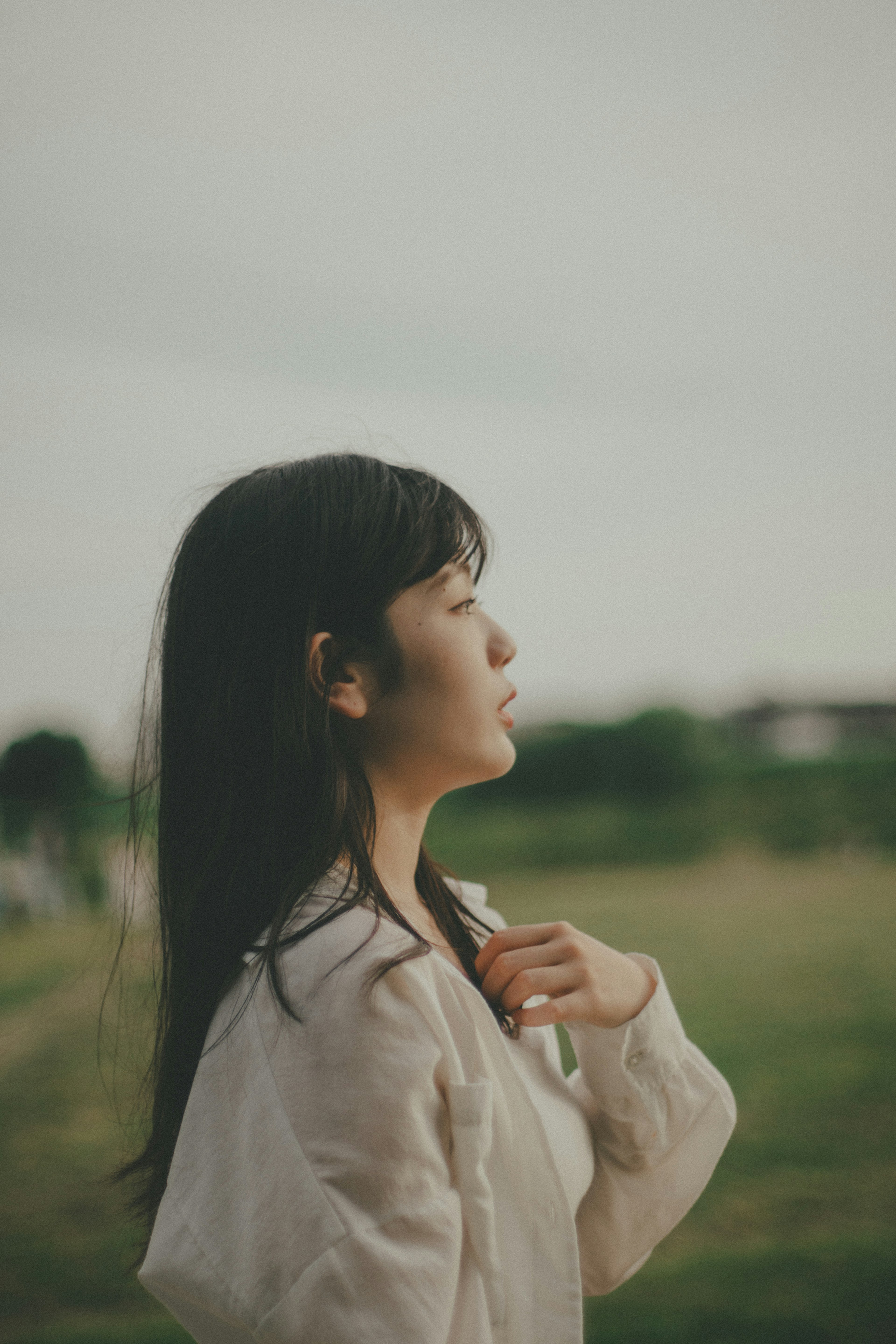 風景の中で考え込む女性の横顔