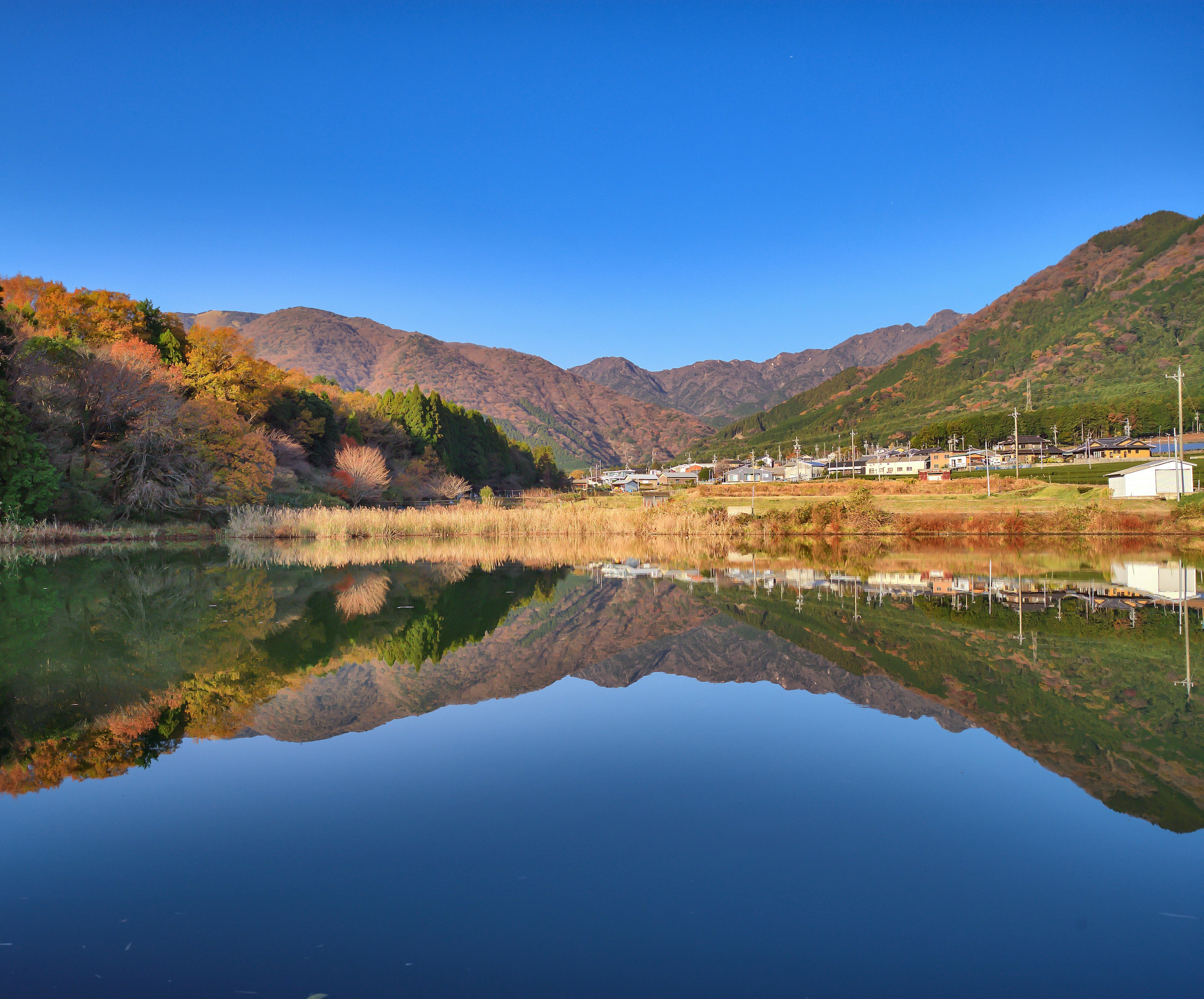 青空と山々の美しい反射がある静かな湖