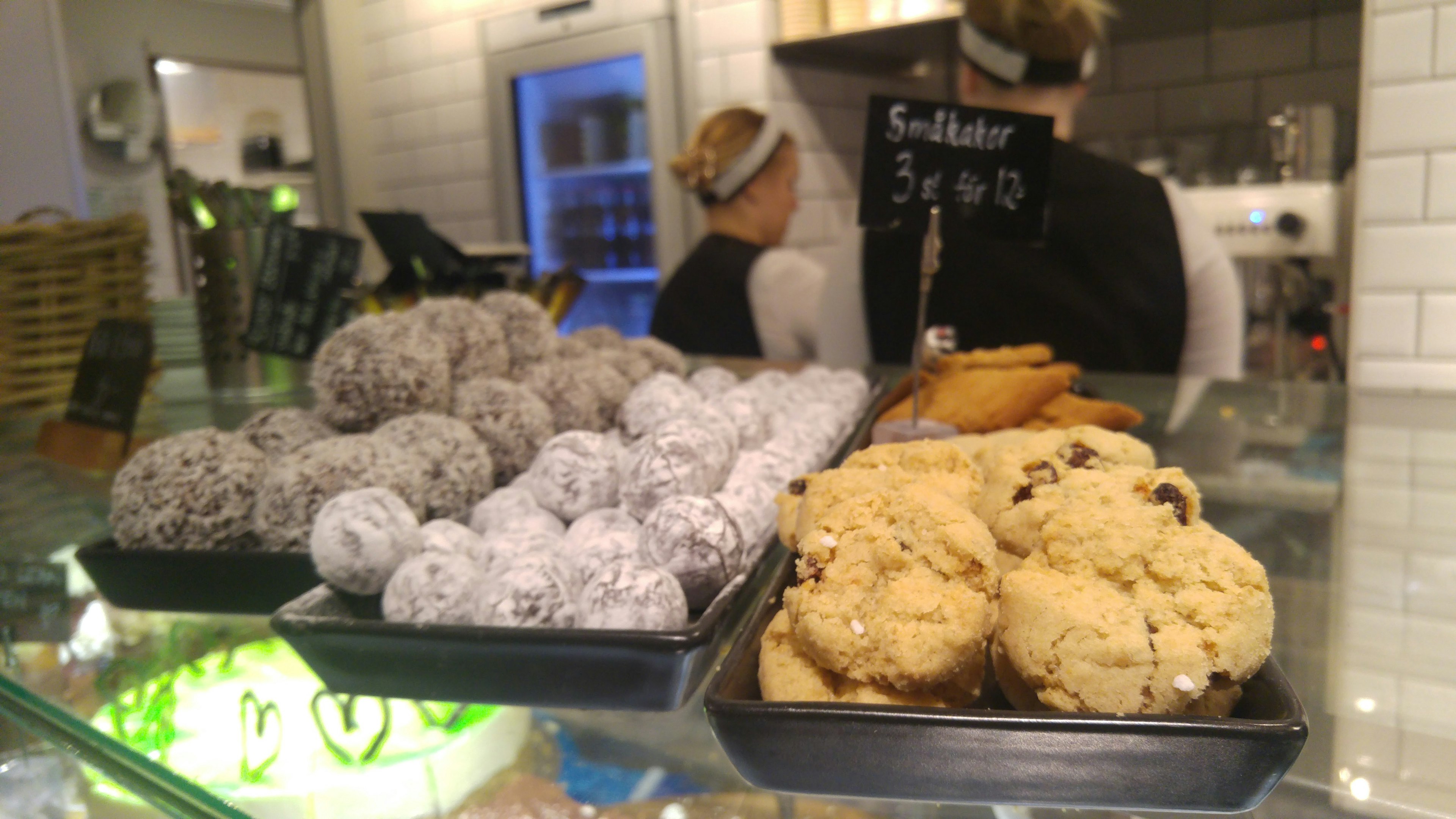 A display of assorted sweets in a cafe with staff at the counter