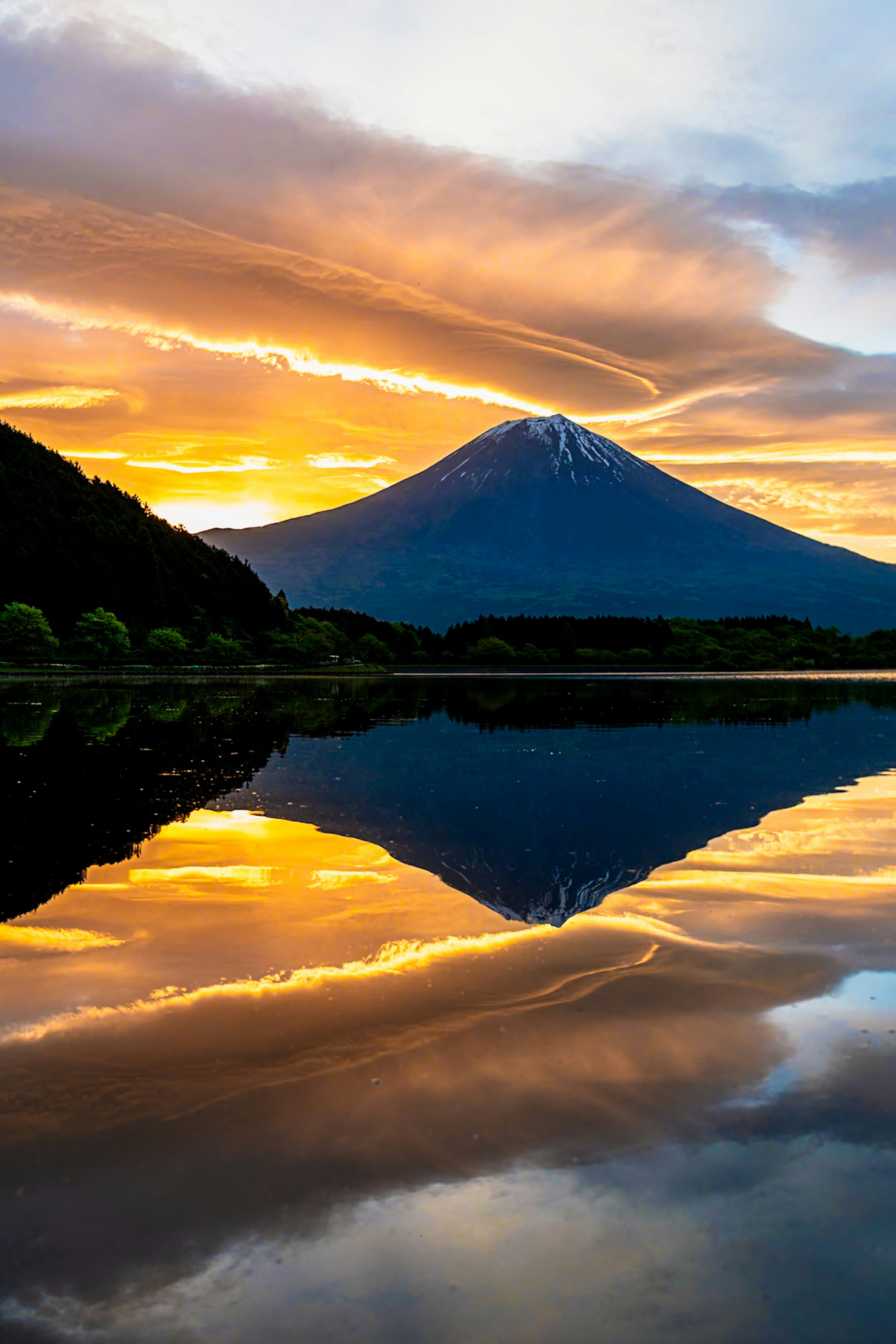 美しい富士山が夕焼けの空を背景に湖に映る