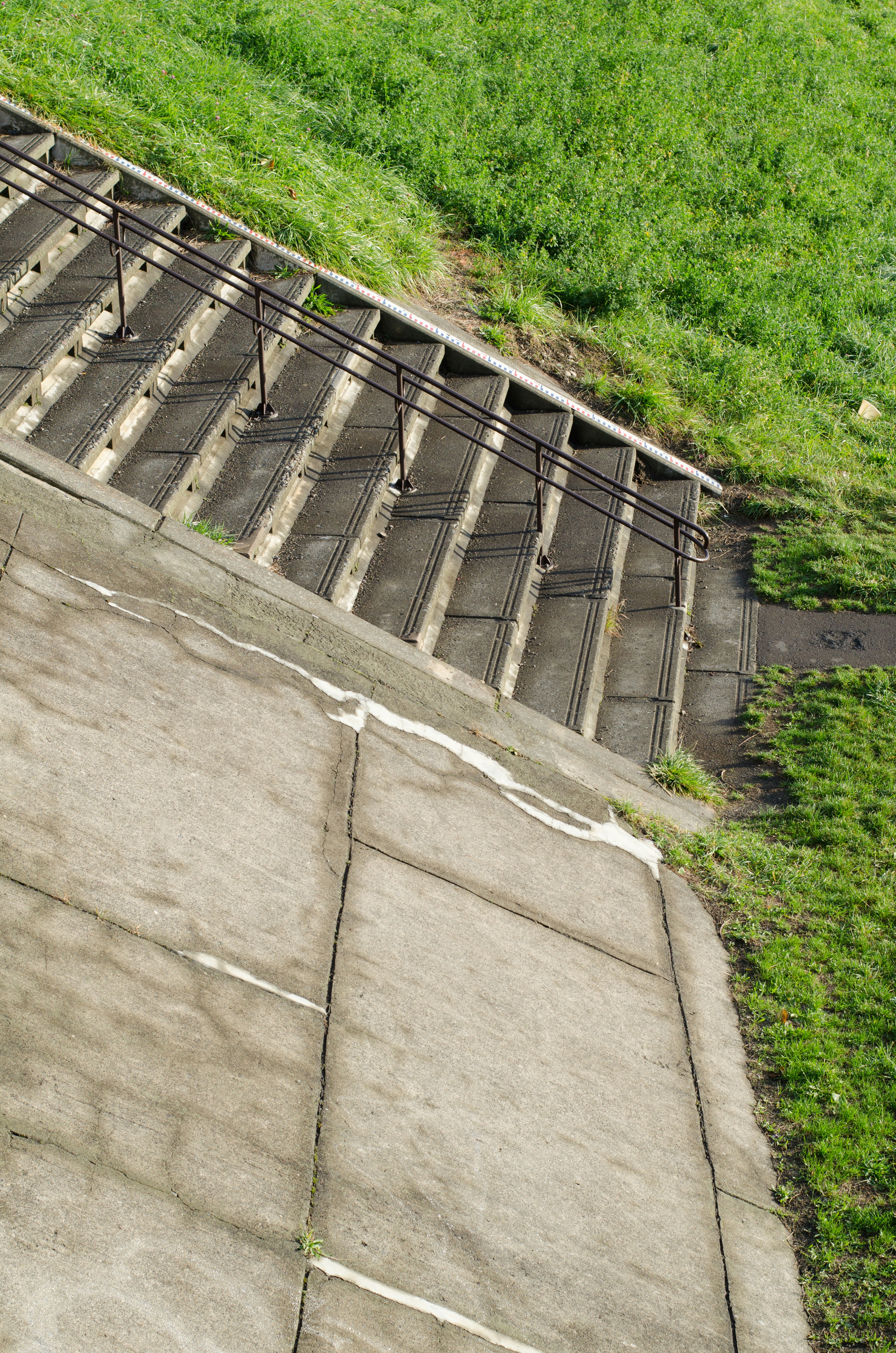 Escaliers en béton diagonaux avec une zone herbeuse à proximité