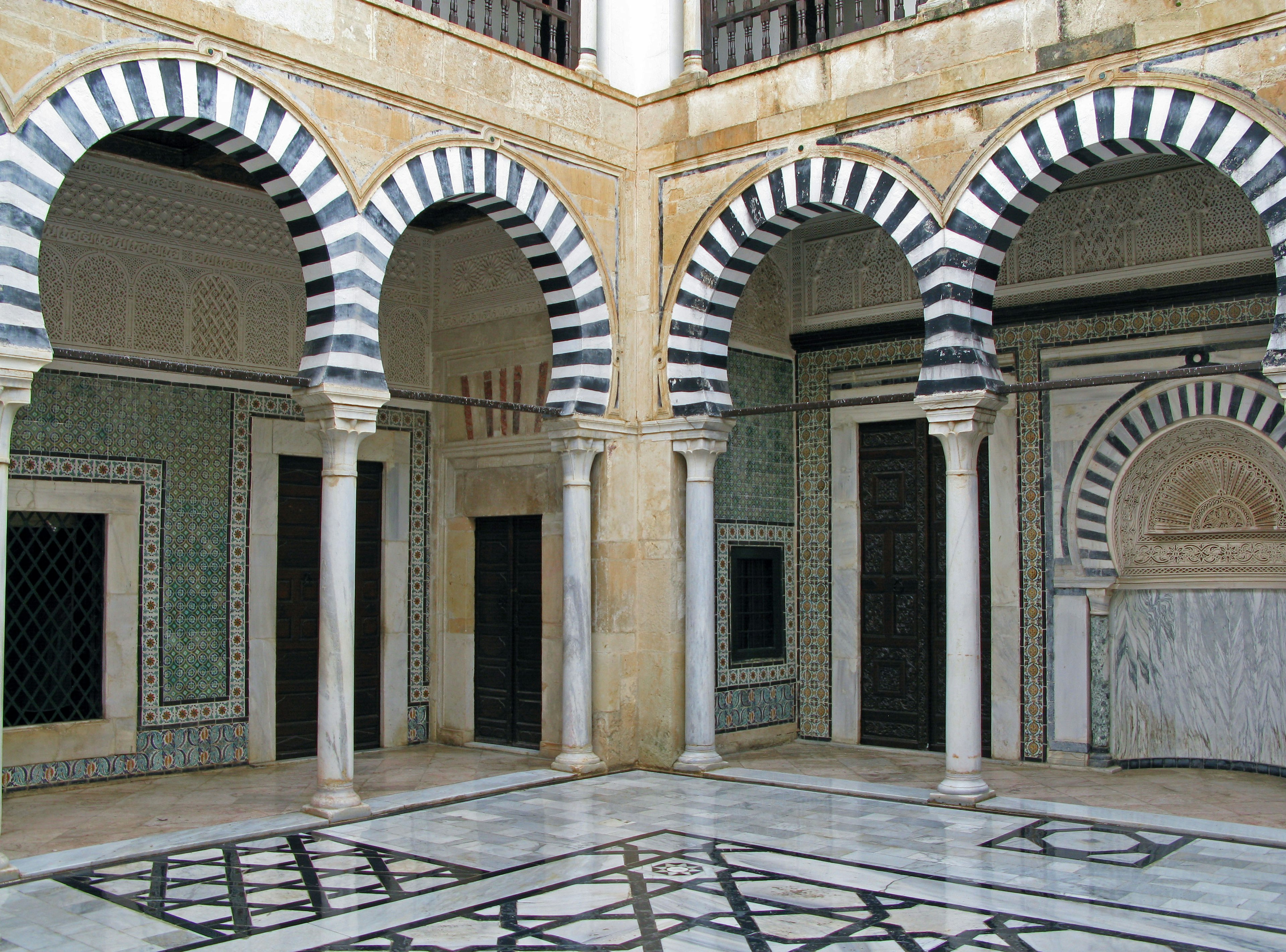 Interno di un edificio storico con bellissime arcate striate e pavimento in marmo