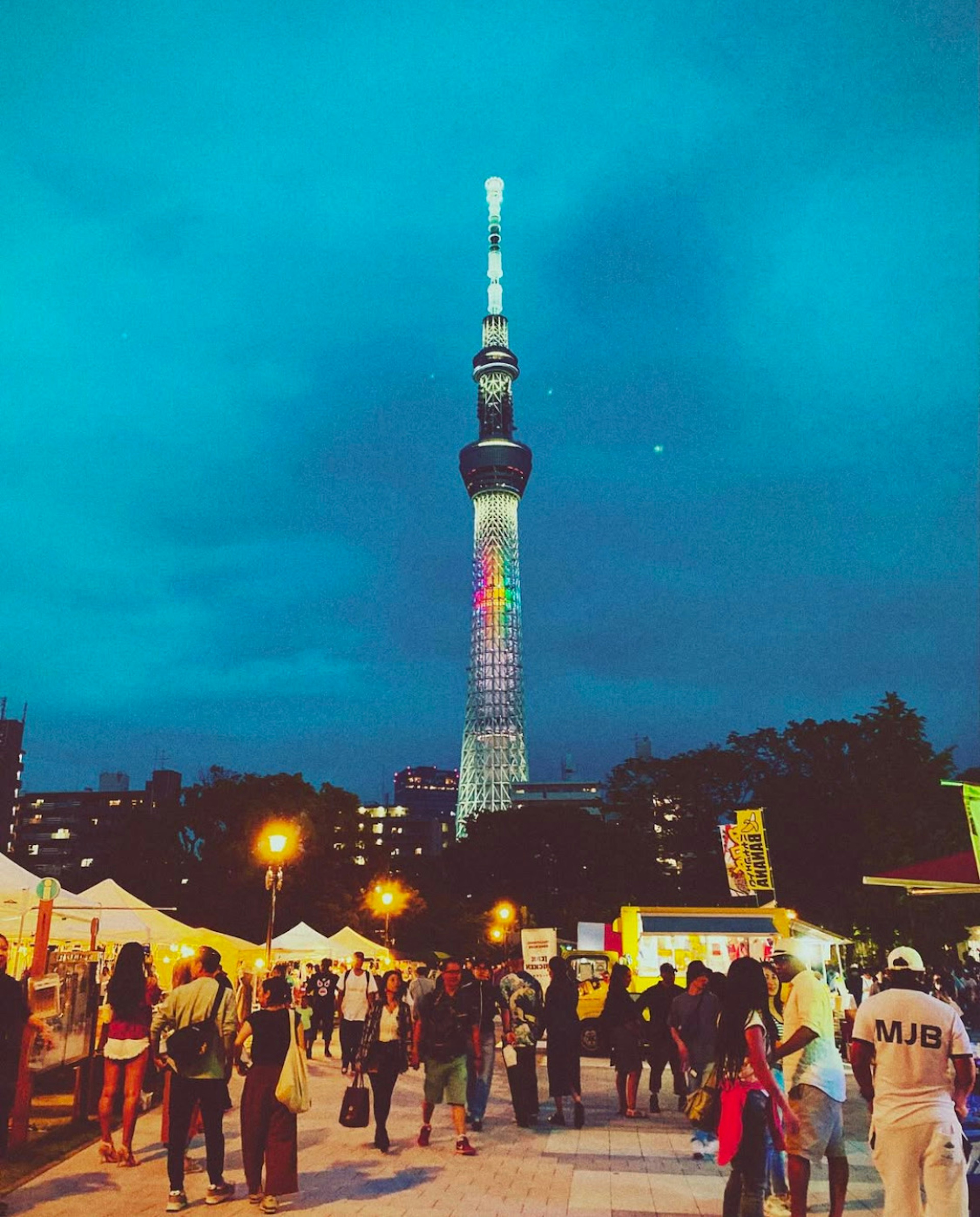 Tokyo Skytree được chiếu sáng vào ban đêm với đám đông nhộn nhịp và lều lễ hội