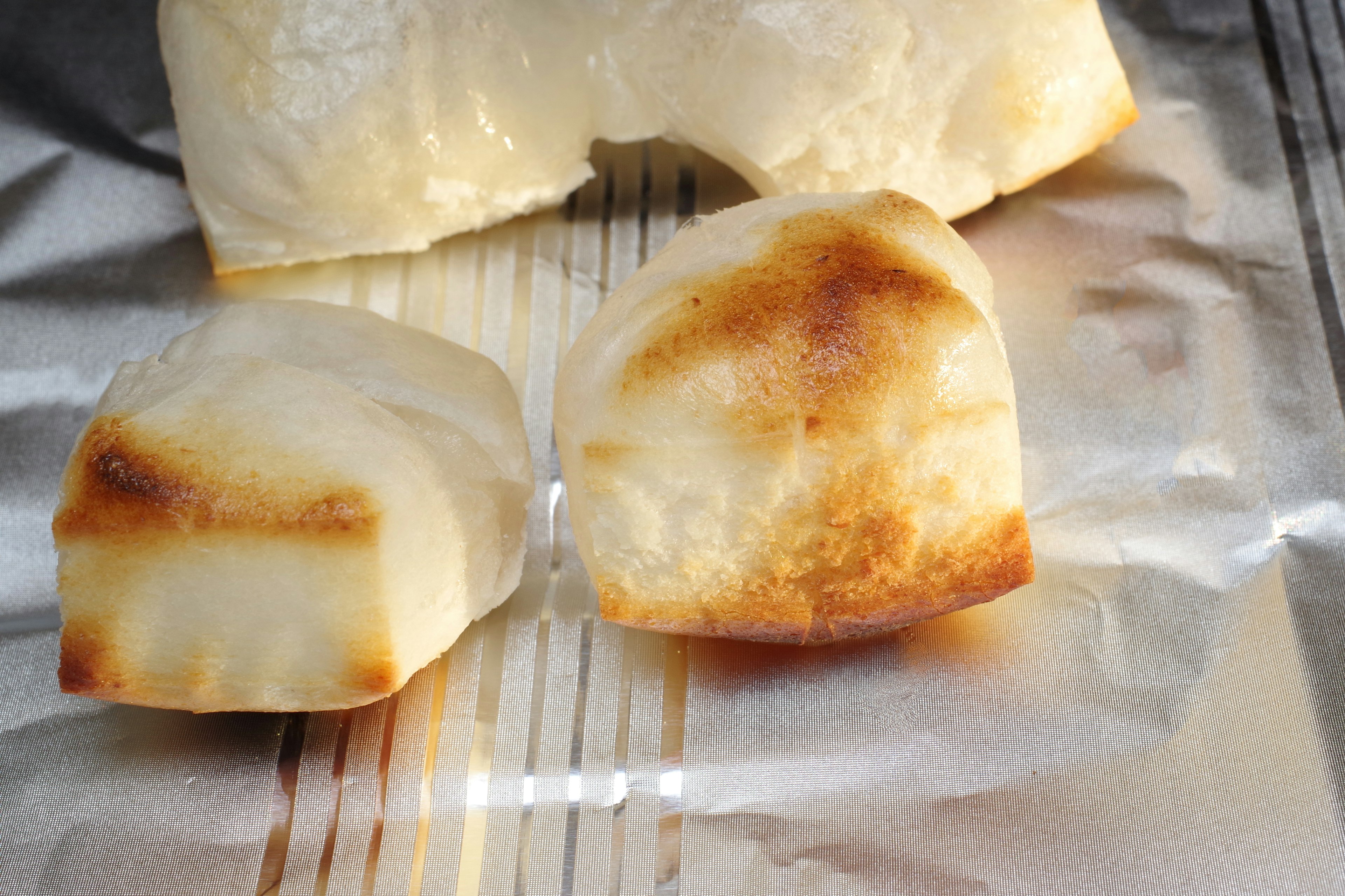 Due pezzi di pane bianco tostato su un foglio di alluminio argentato