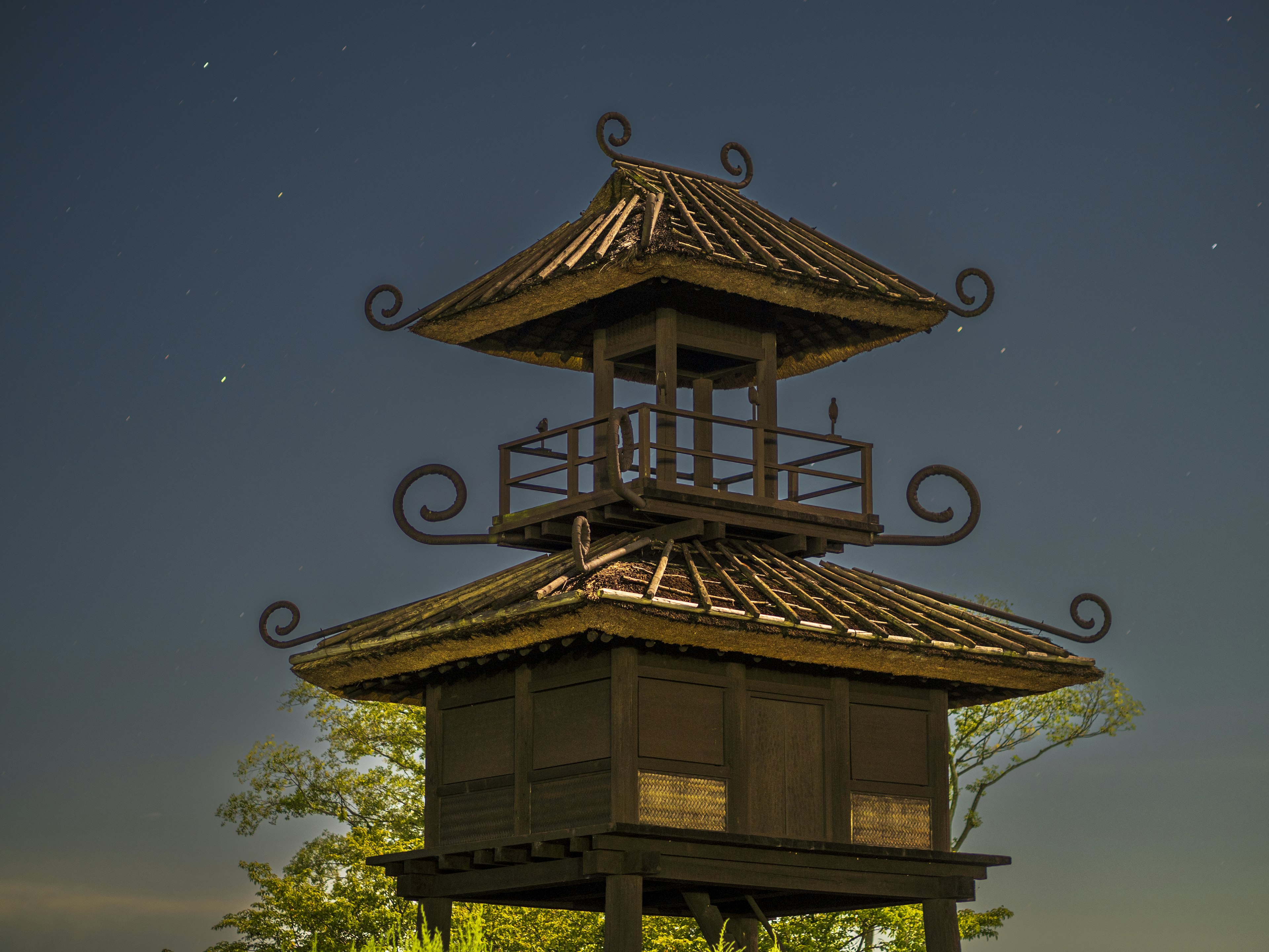 Image d'une belle tour en bois illuminée par le ciel nocturne