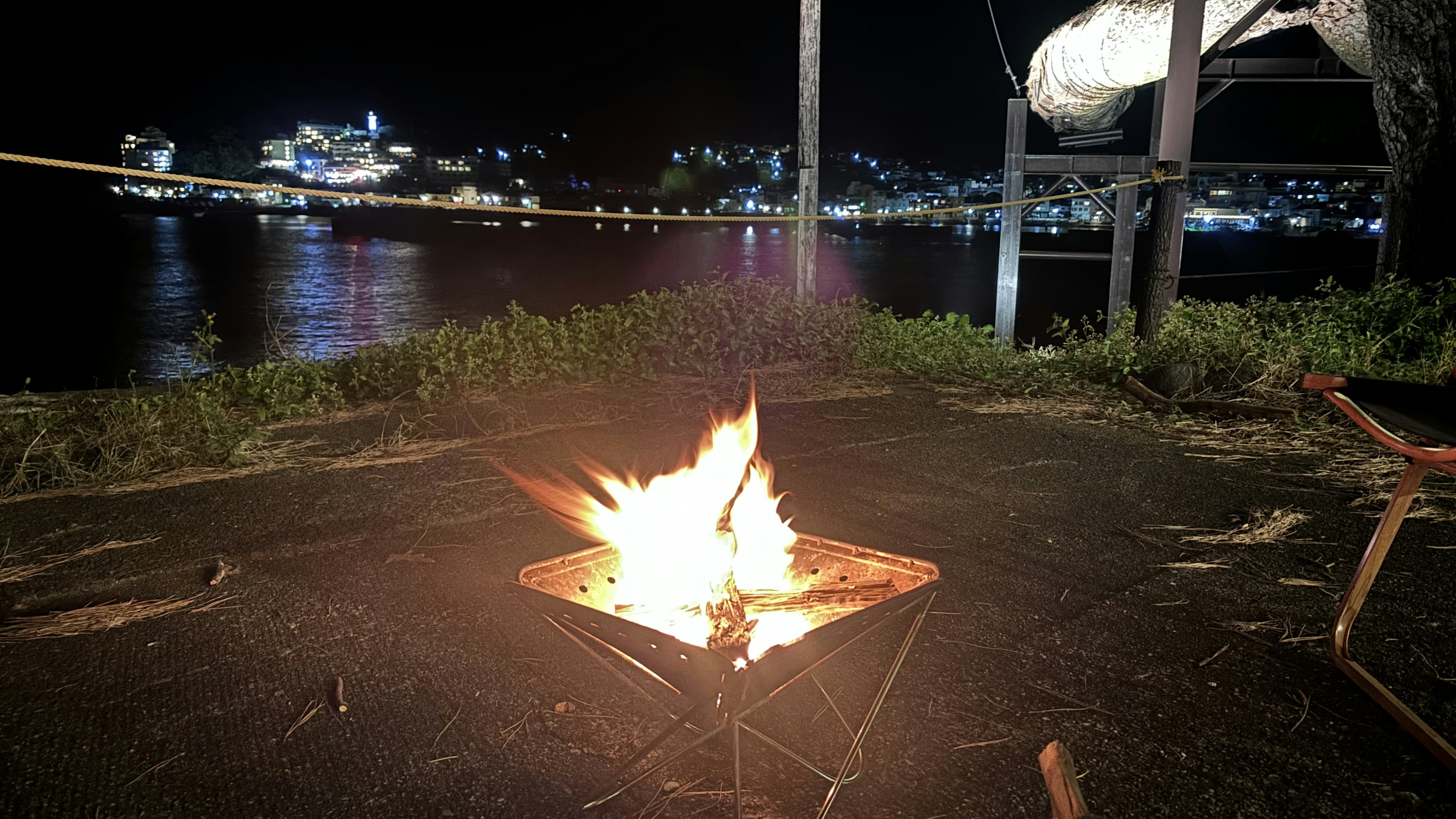 夜の海辺で焚き火が燃えている風景