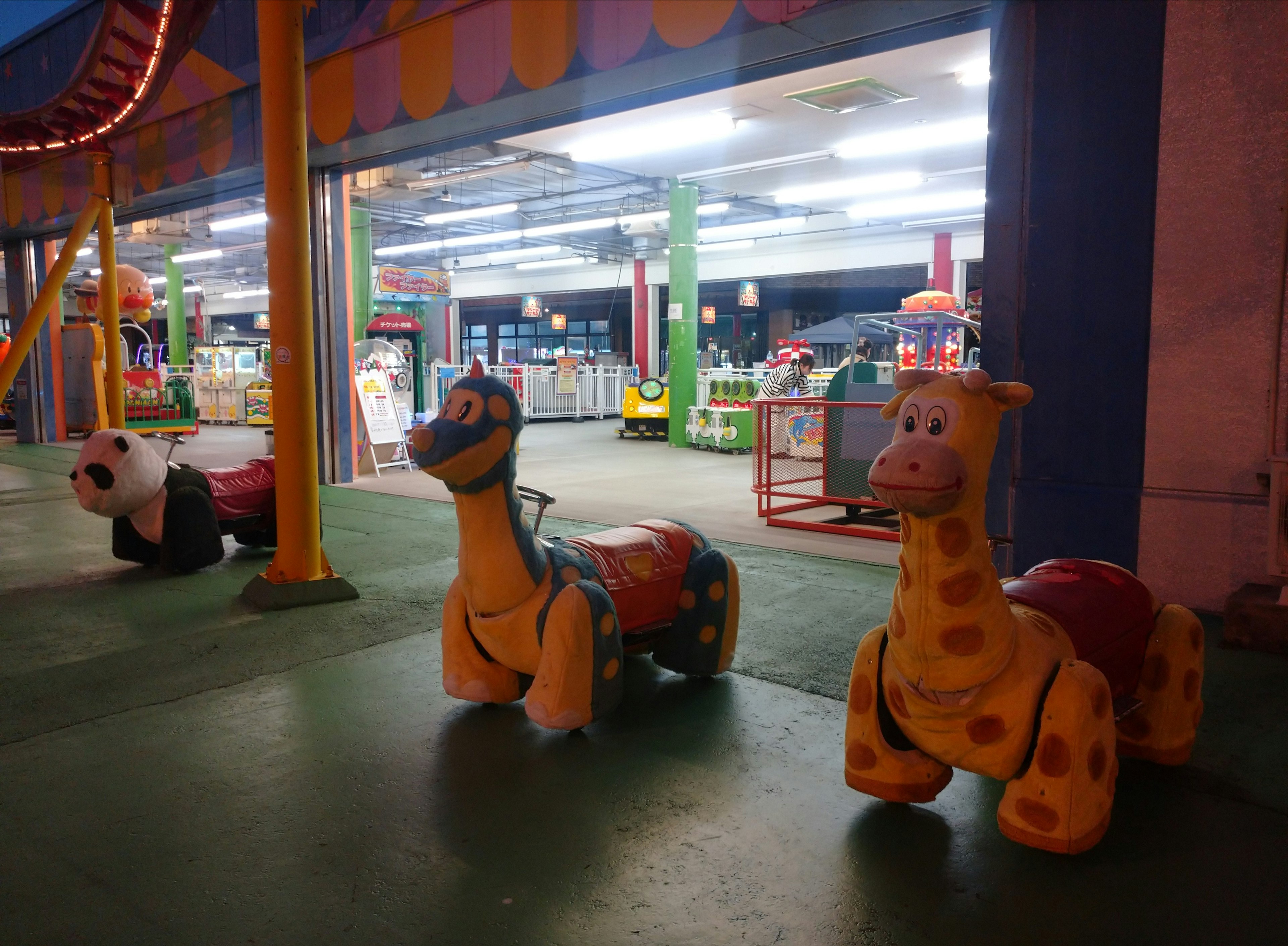 Vue nocturne de manèges en forme d'animaux dans un parc d'attractions