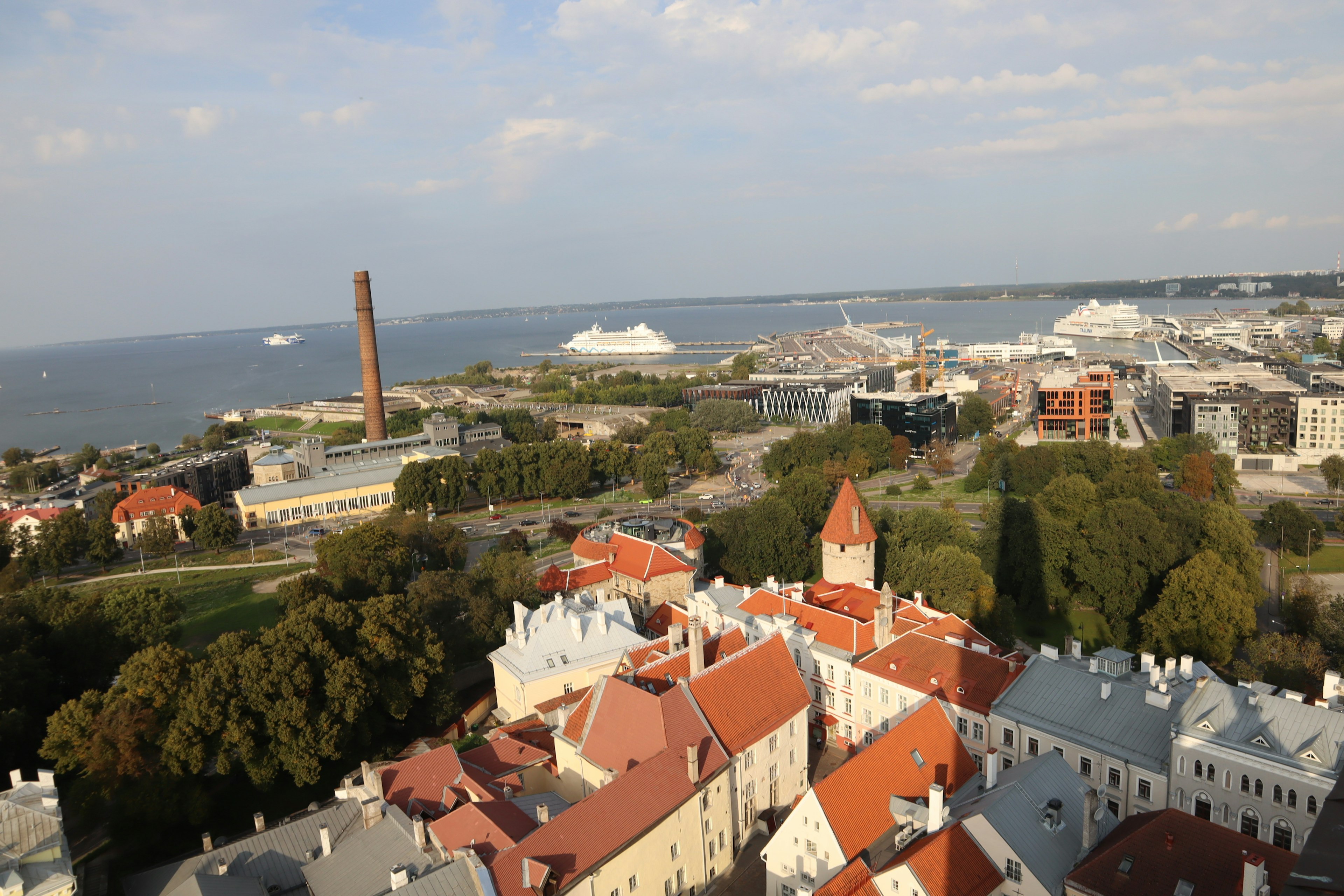 Pemandangan kota tua Tallinn dan pelabuhan dengan bangunan atap merah dan laut