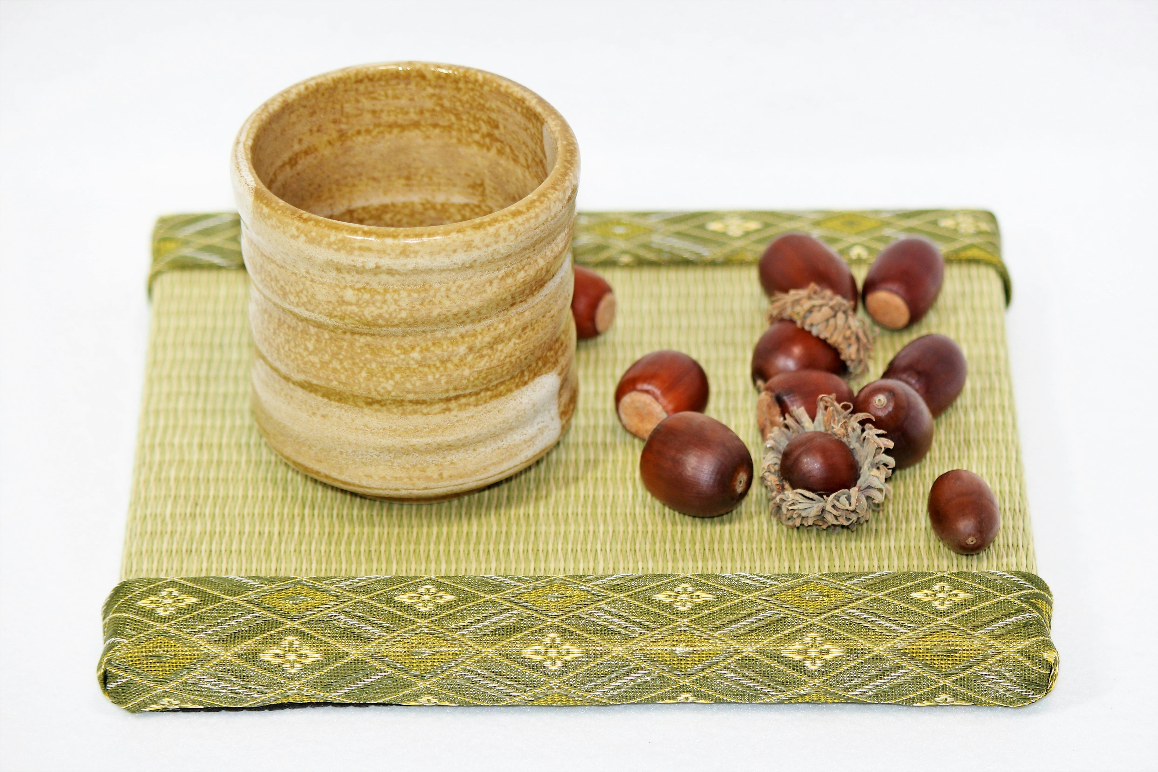 Tazza di legno con ghianda su un tappetino verde