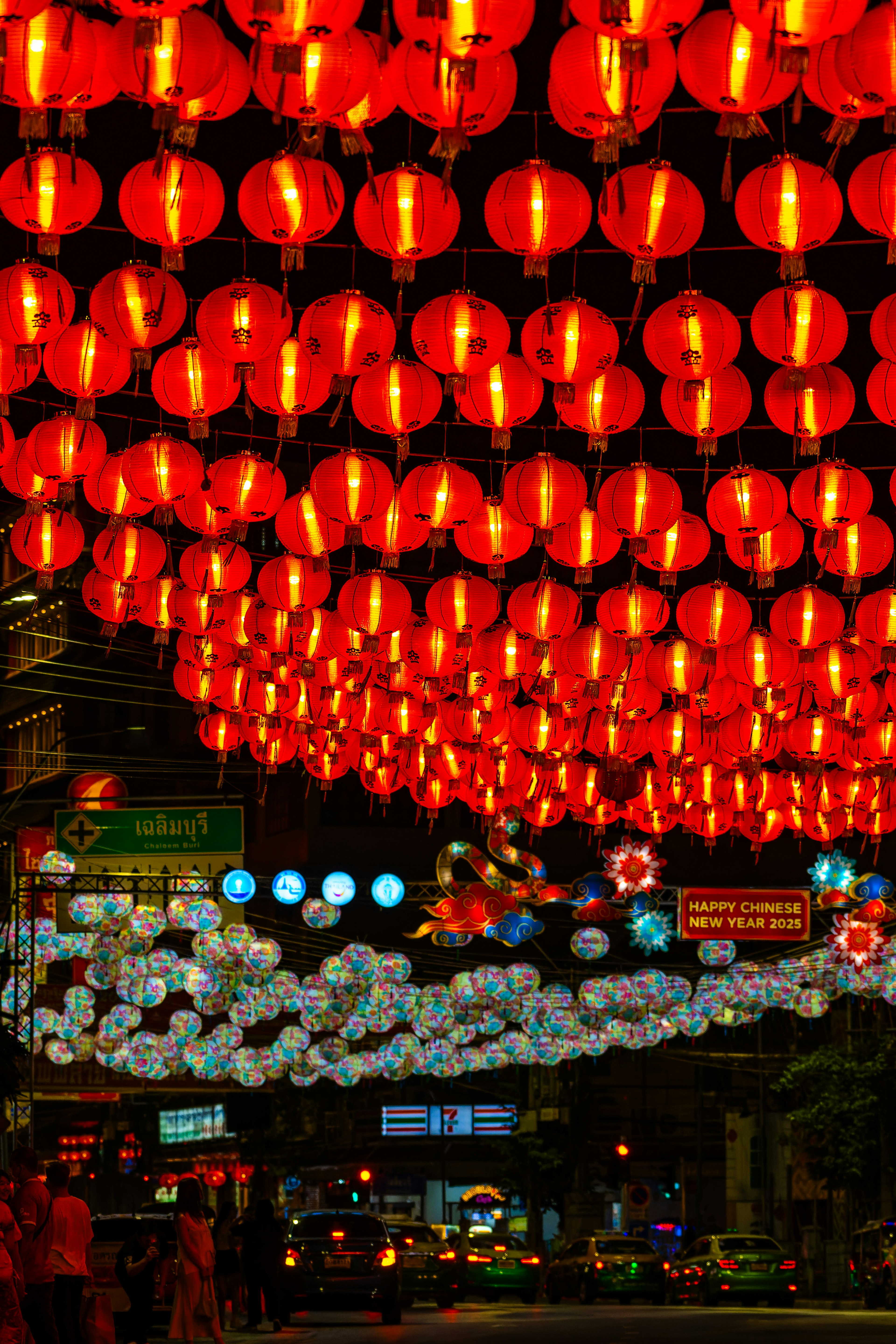 A vibrant night market scene filled with red lanterns hanging above