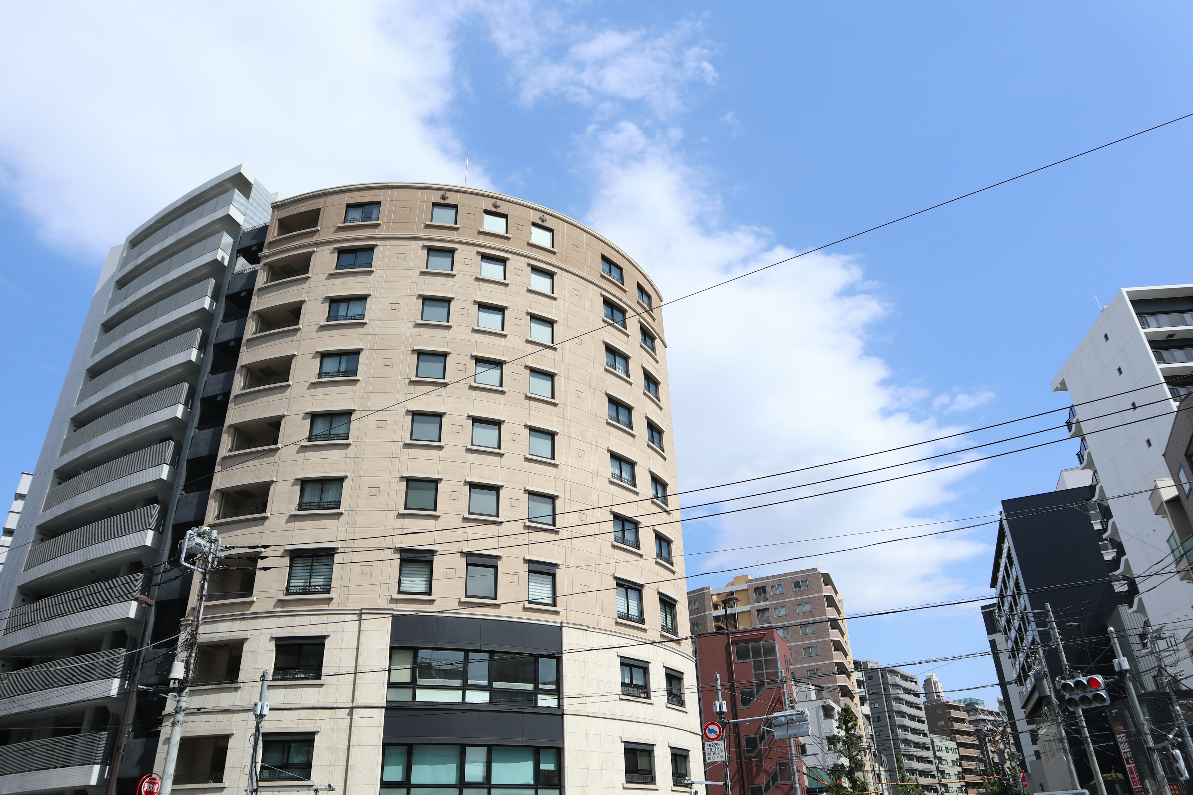 Circular building under a blue sky with modern buildings nearby