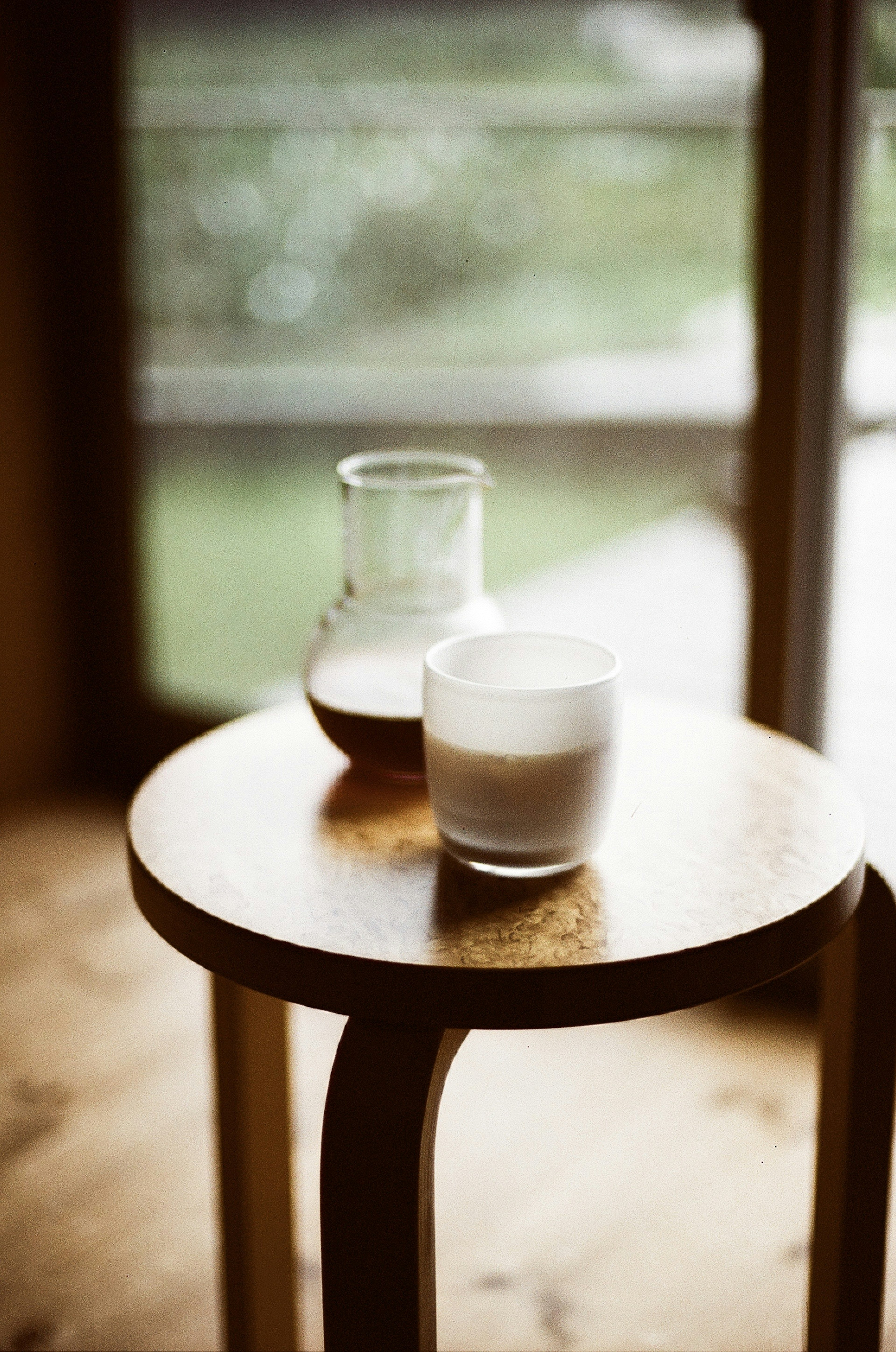 Glass containers of milk and coffee on a wooden table