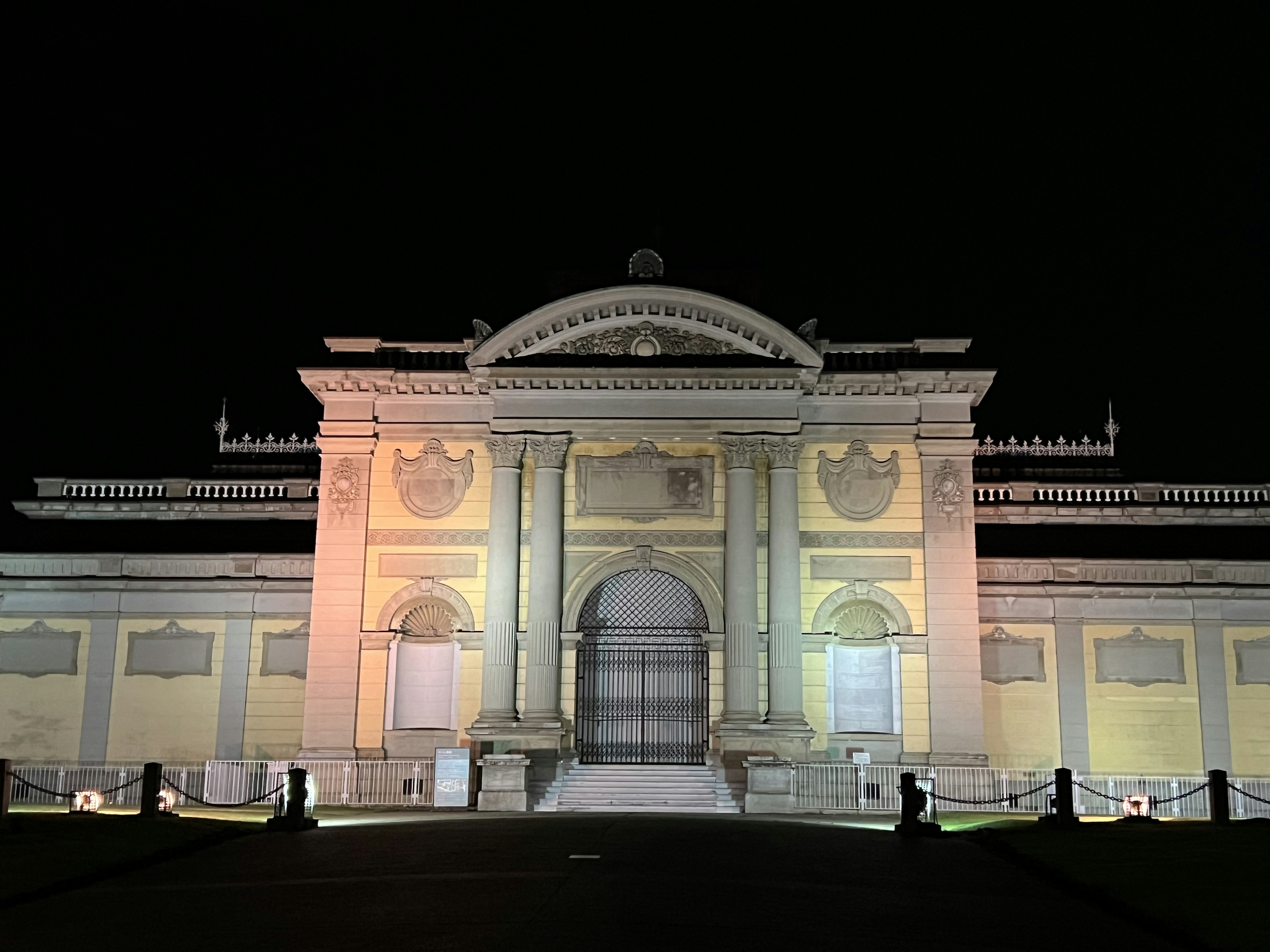 Beleuchtete Fassade eines historischen Gebäudes bei Nacht mit komplizierten architektonischen Details