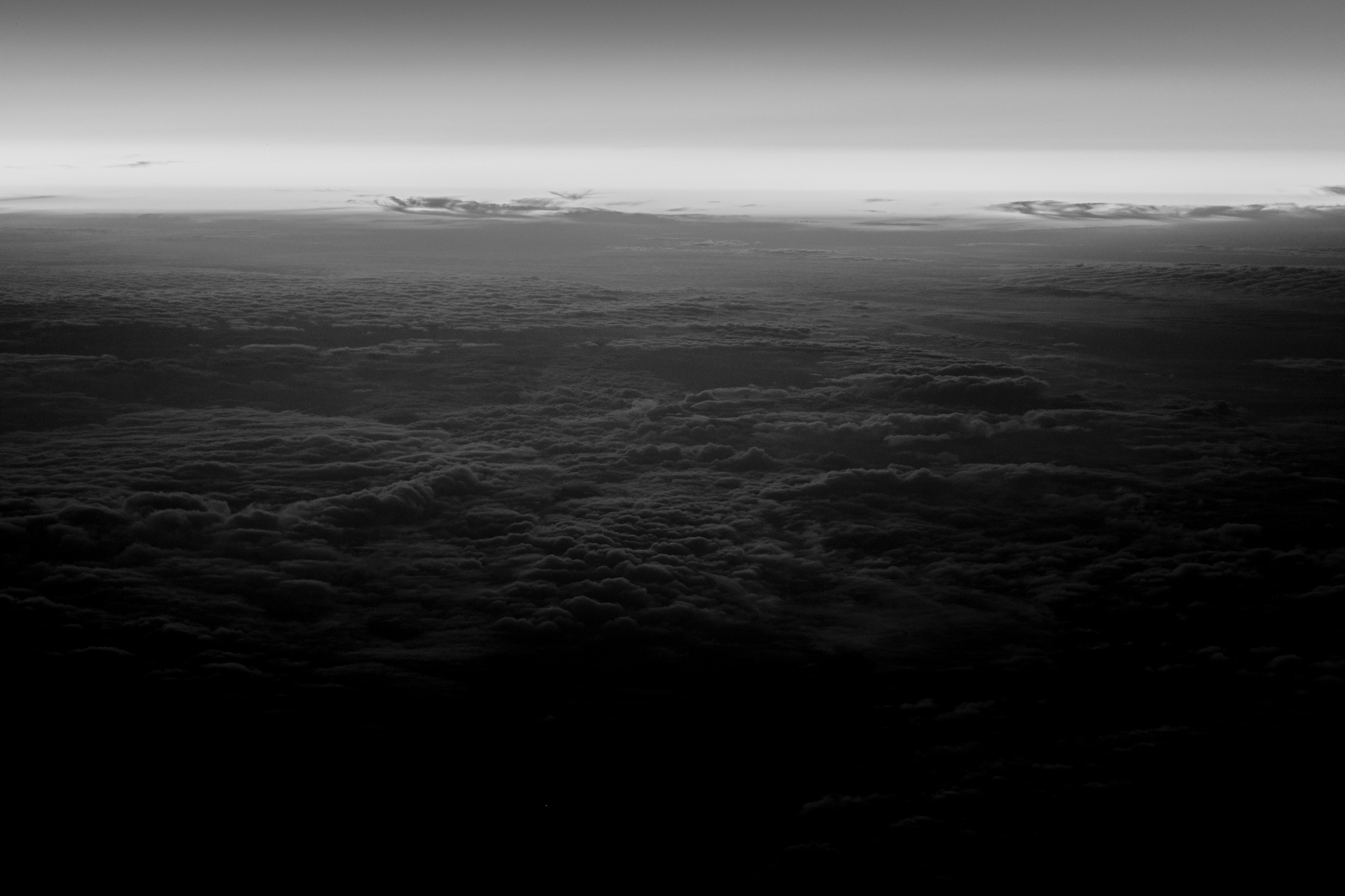 Una vista en blanco y negro de capas de nubes con un cielo degradado