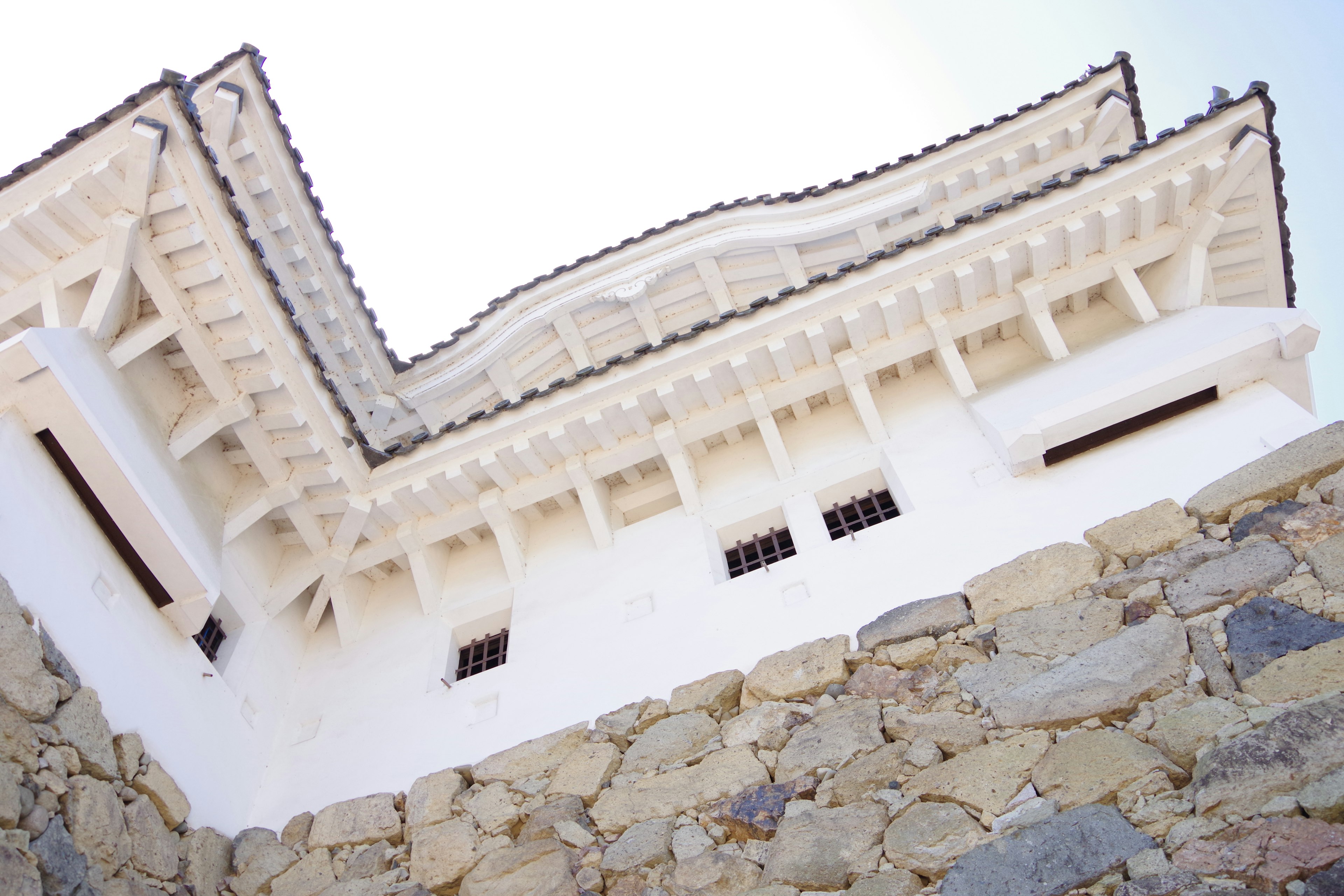 Details des weißen Schlossdachs und der Steinmauer sichtbar