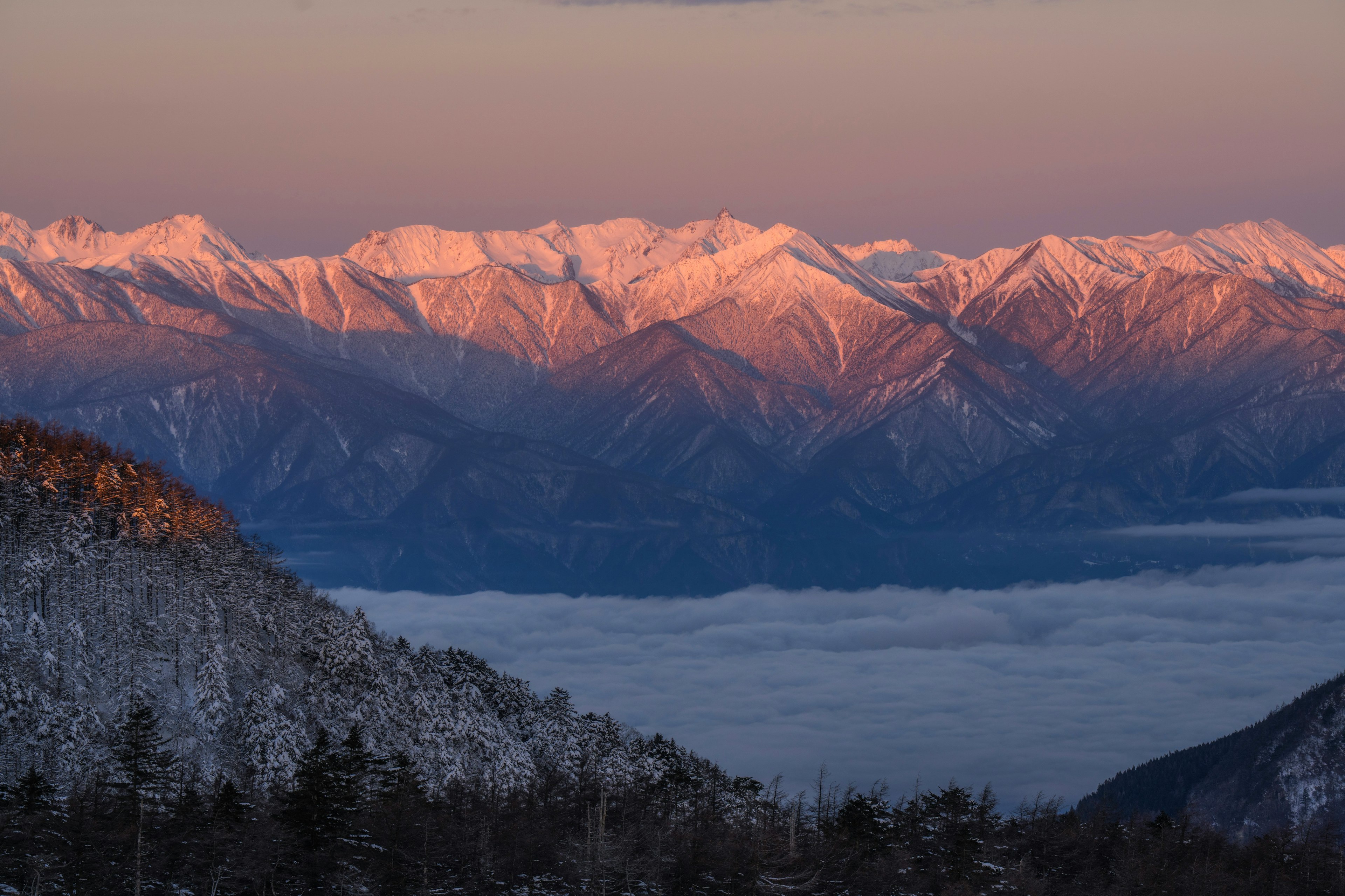 Verschneite Berge mit Sonnenuntergangshimmel