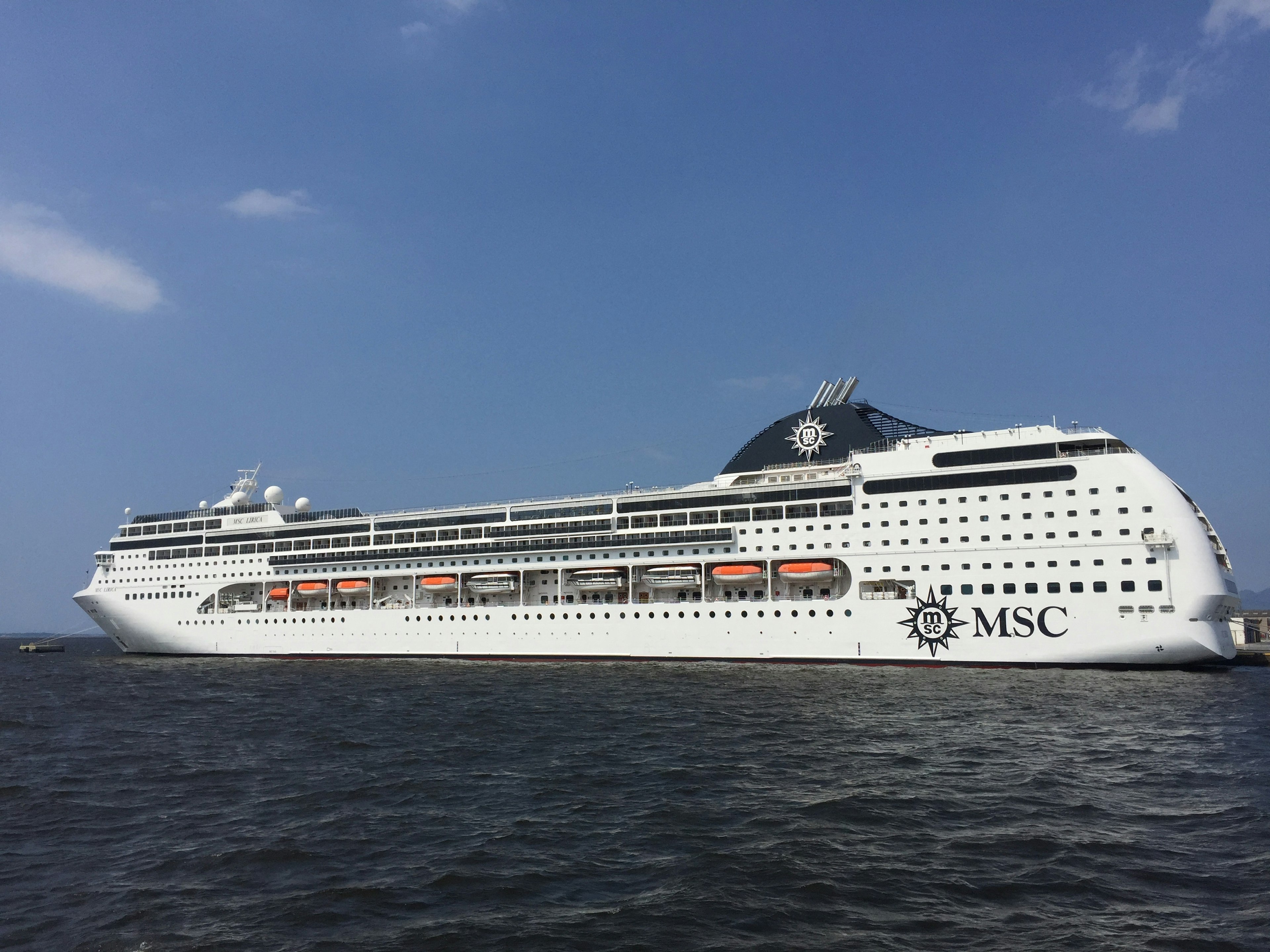 Luxury MSC cruise ship sailing under a clear blue sky