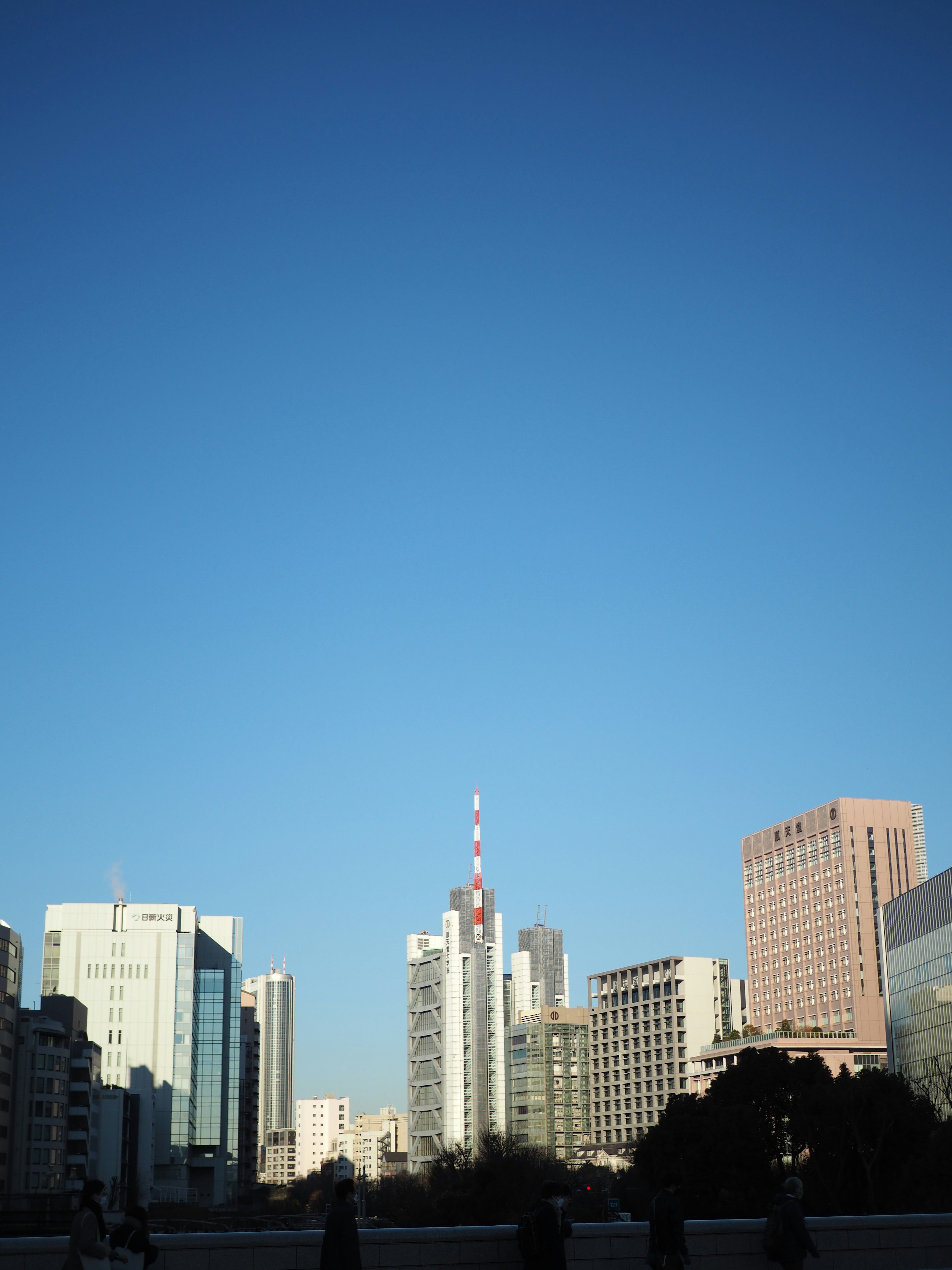 City skyline featuring tall buildings under a clear blue sky