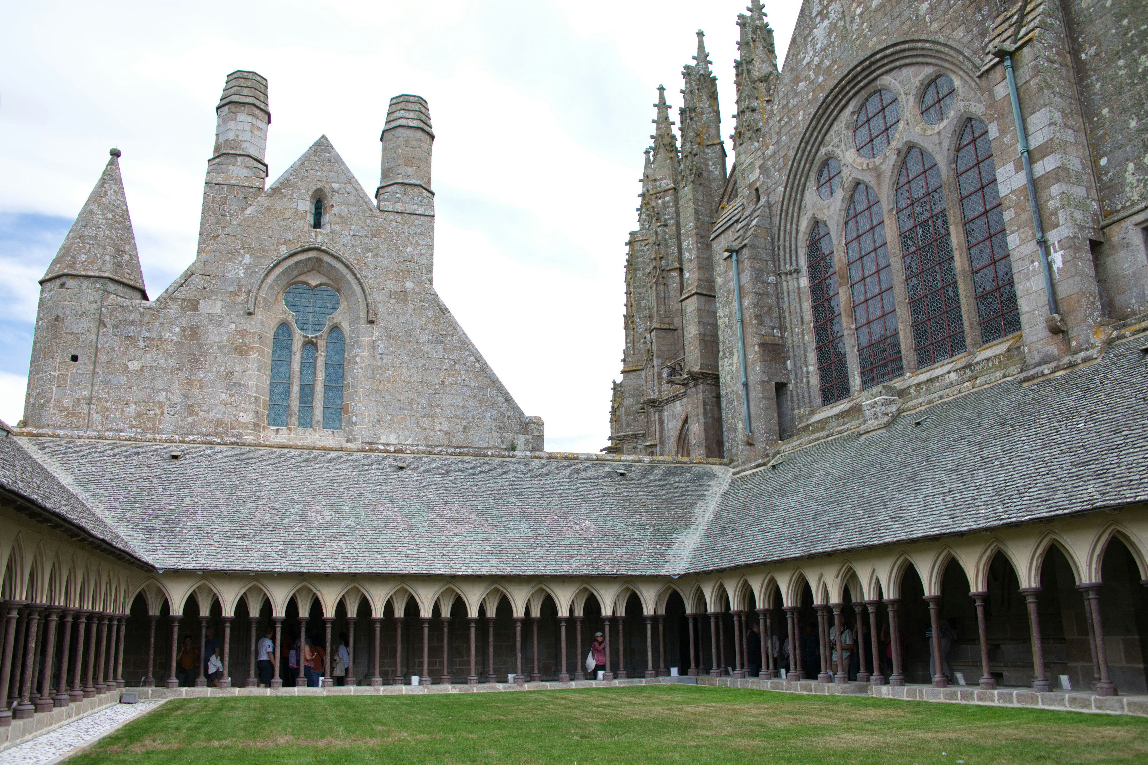 View of a monastery courtyard featuring medieval architecture and beautiful stained glass