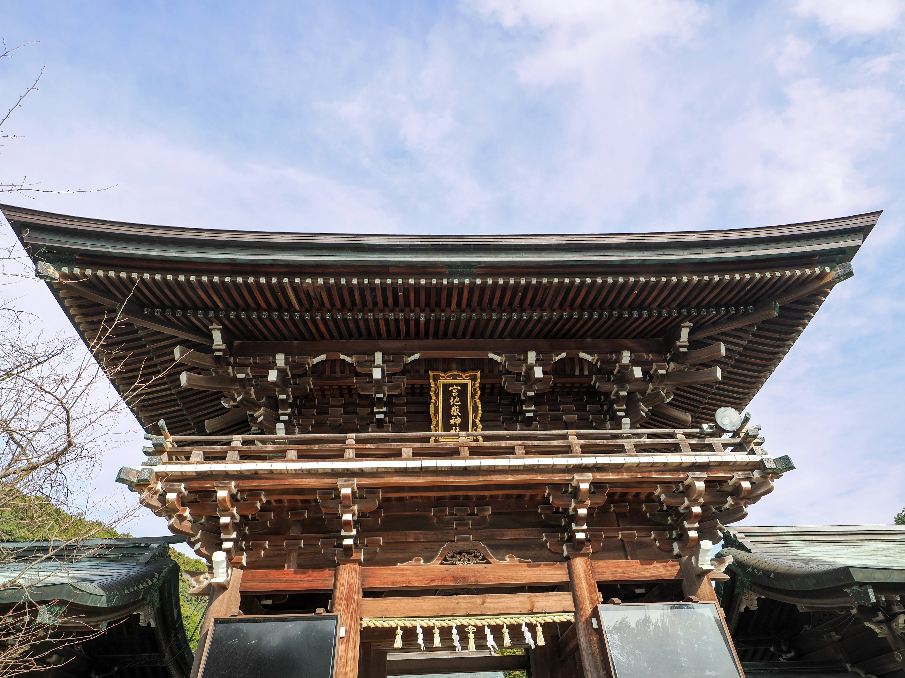 从下方观看美丽的神社门，背景是蓝天和云朵