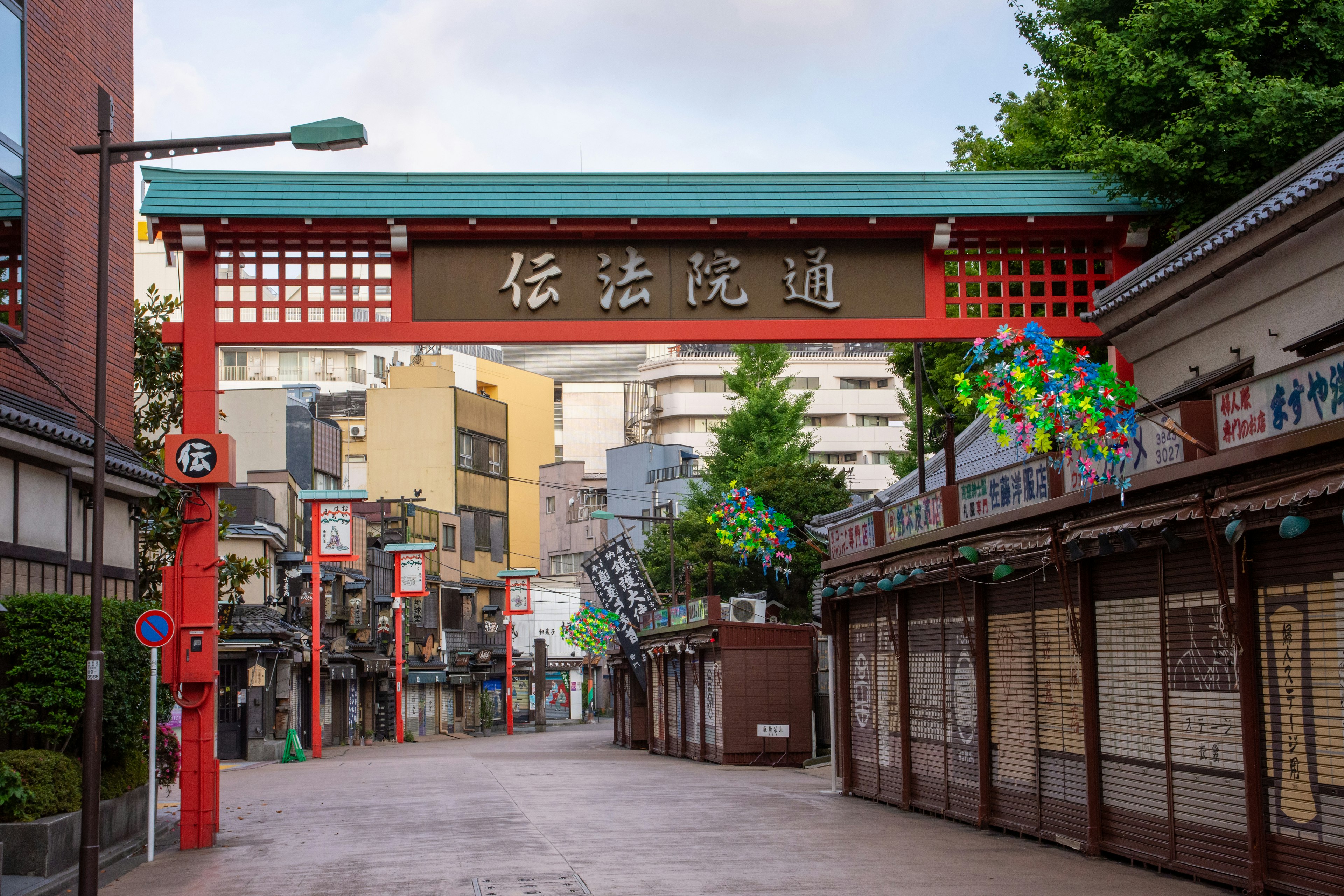 Puerta roja con una calle comercial tradicional al fondo