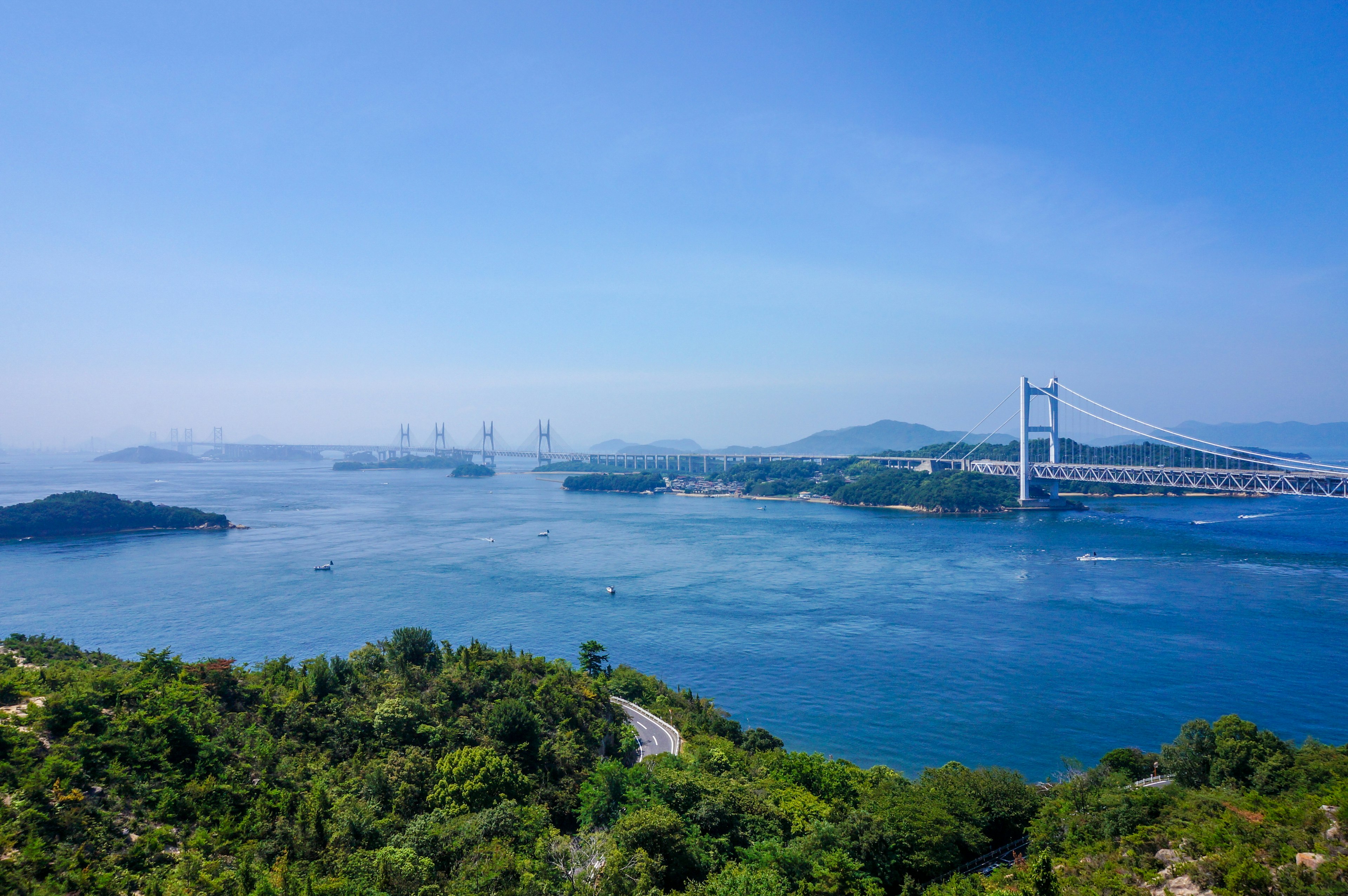 Scenic view of blue sky and sea featuring a bridge and islands