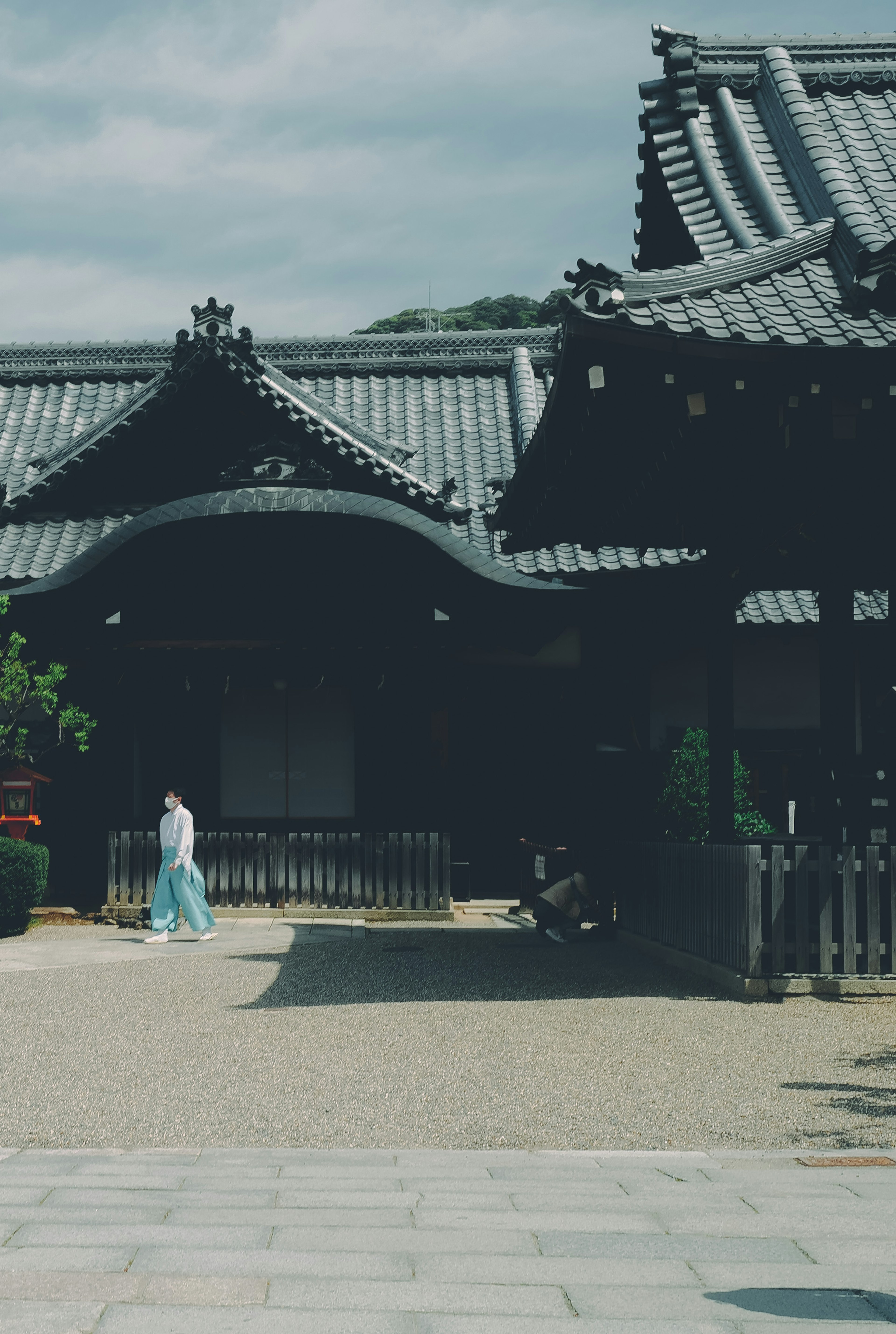 Une femme en vêtements traditionnels marchant devant un bâtiment de style japonais